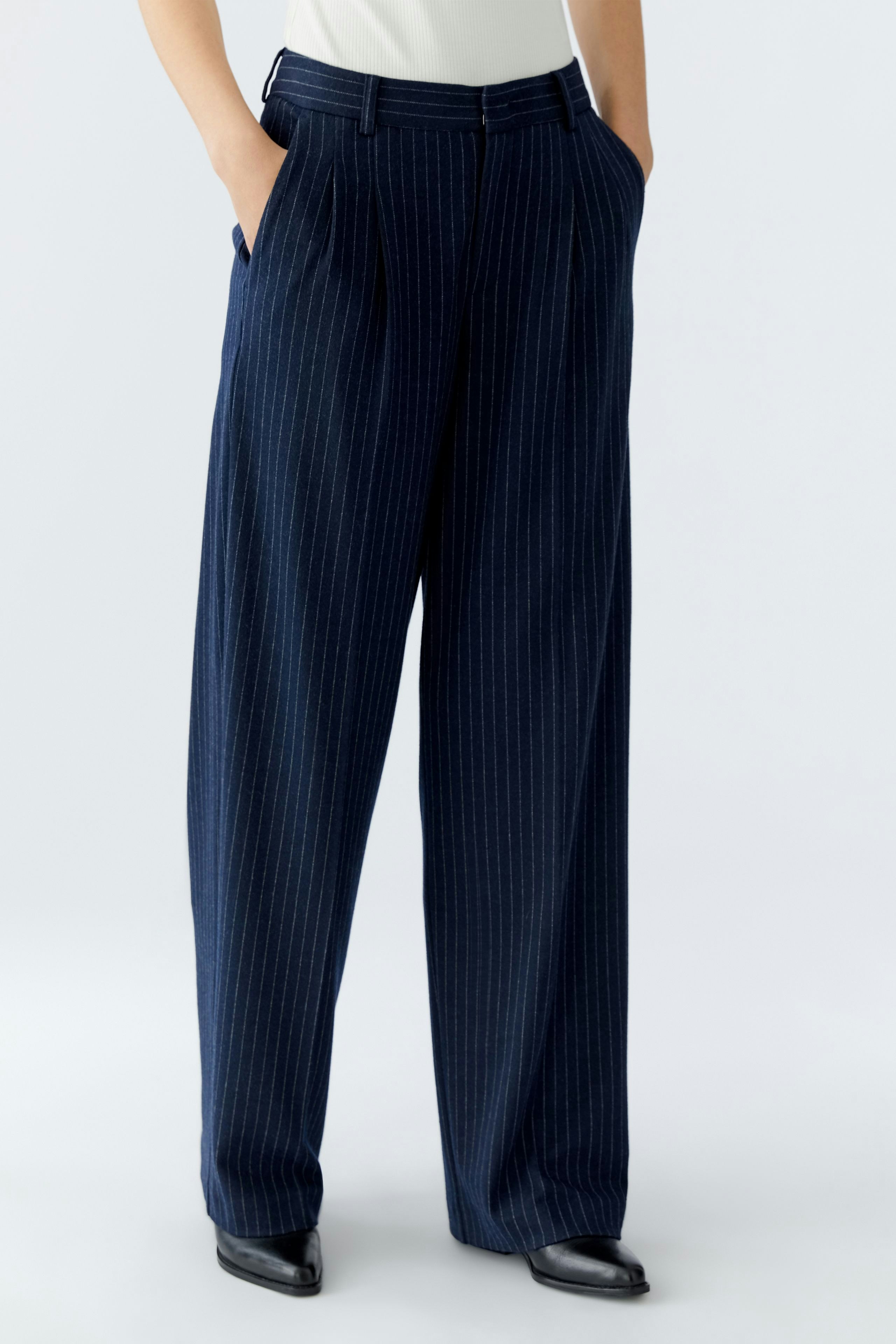 Stylish women's pleated trousers in navy with pinstripes, offering a relaxed fit and modern look.