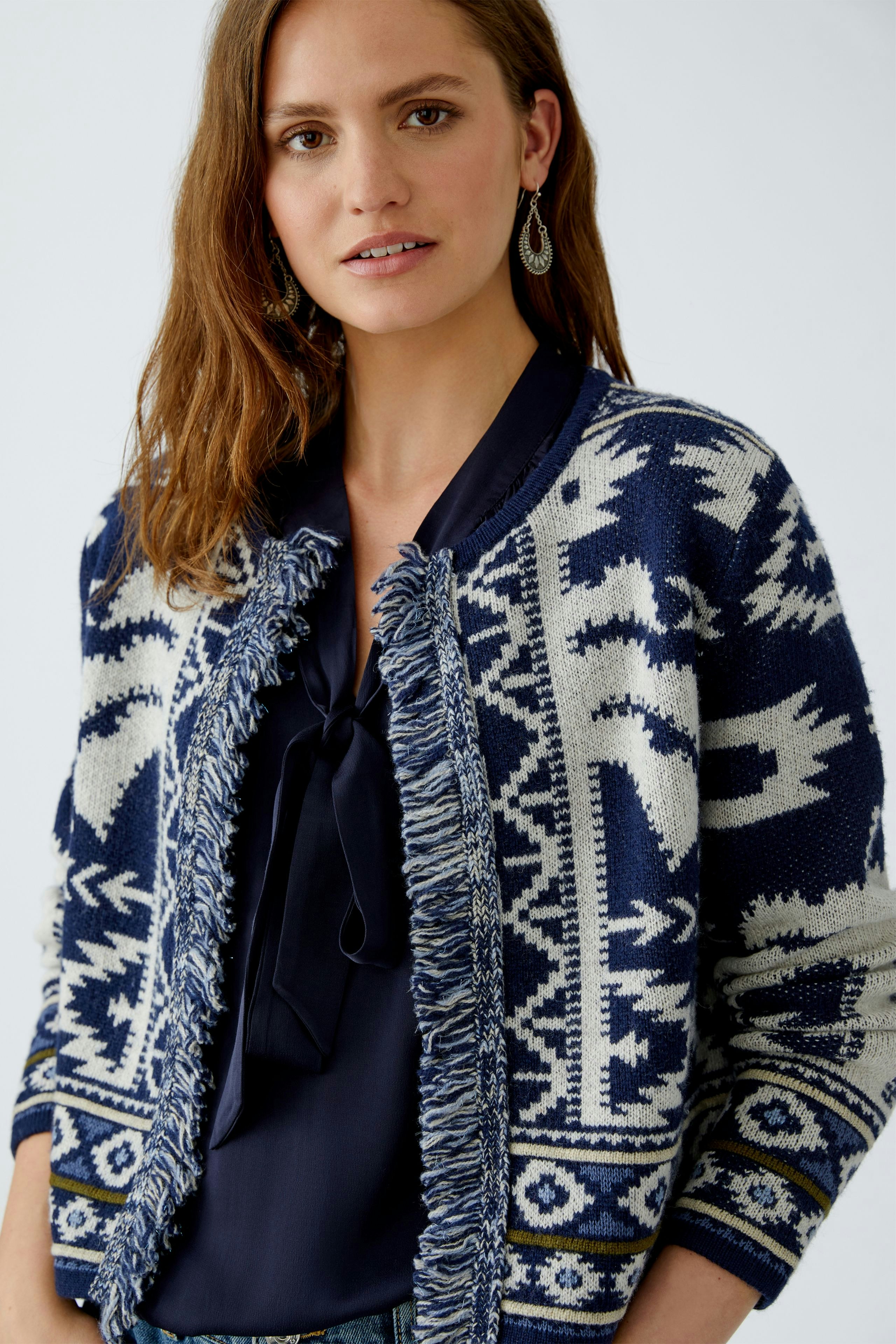 Casual women's cardigan: A woman in a navy patterned cardigan with fringes, paired with a dark blouse.