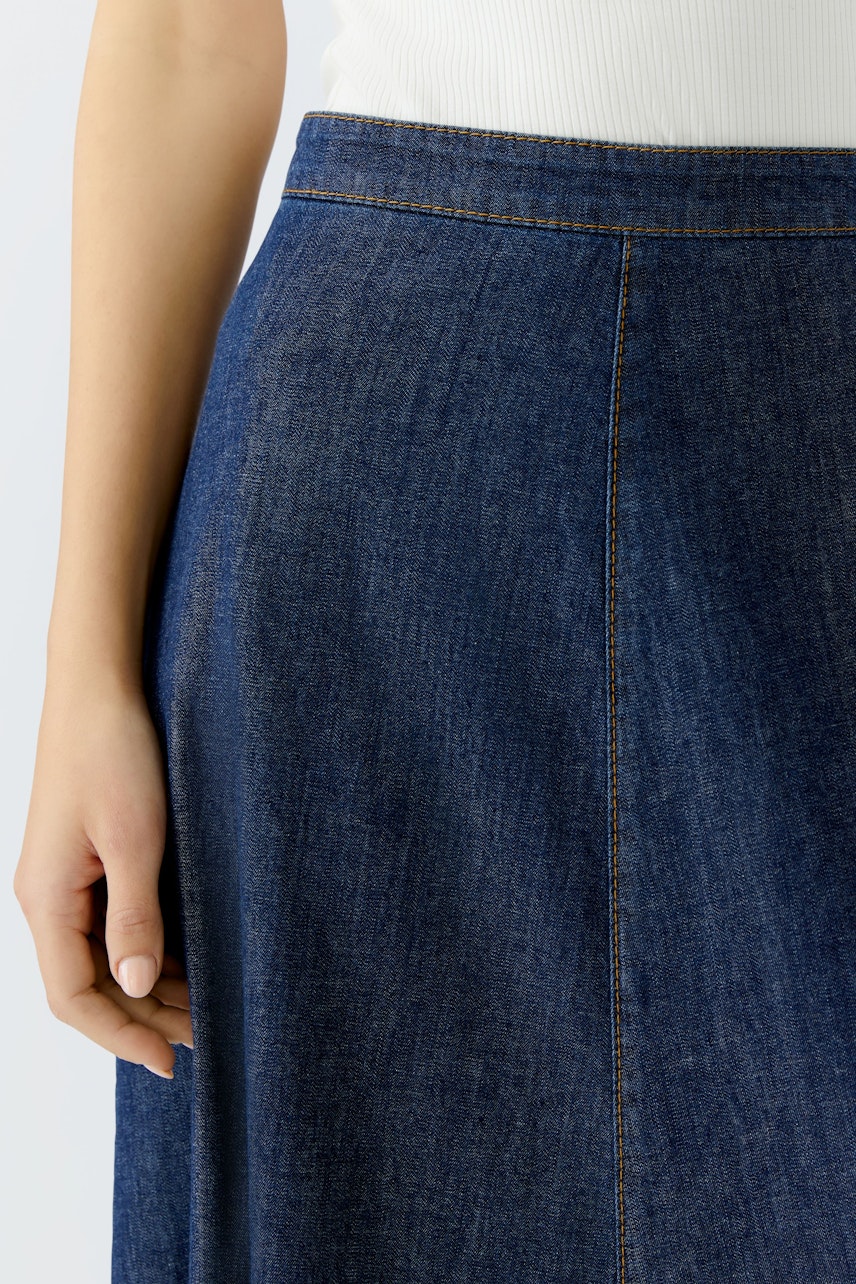 Damen-Jeansrock: Frau trägt einen blauen Jeansrock mit geradem Schnitt und lässigem Design.