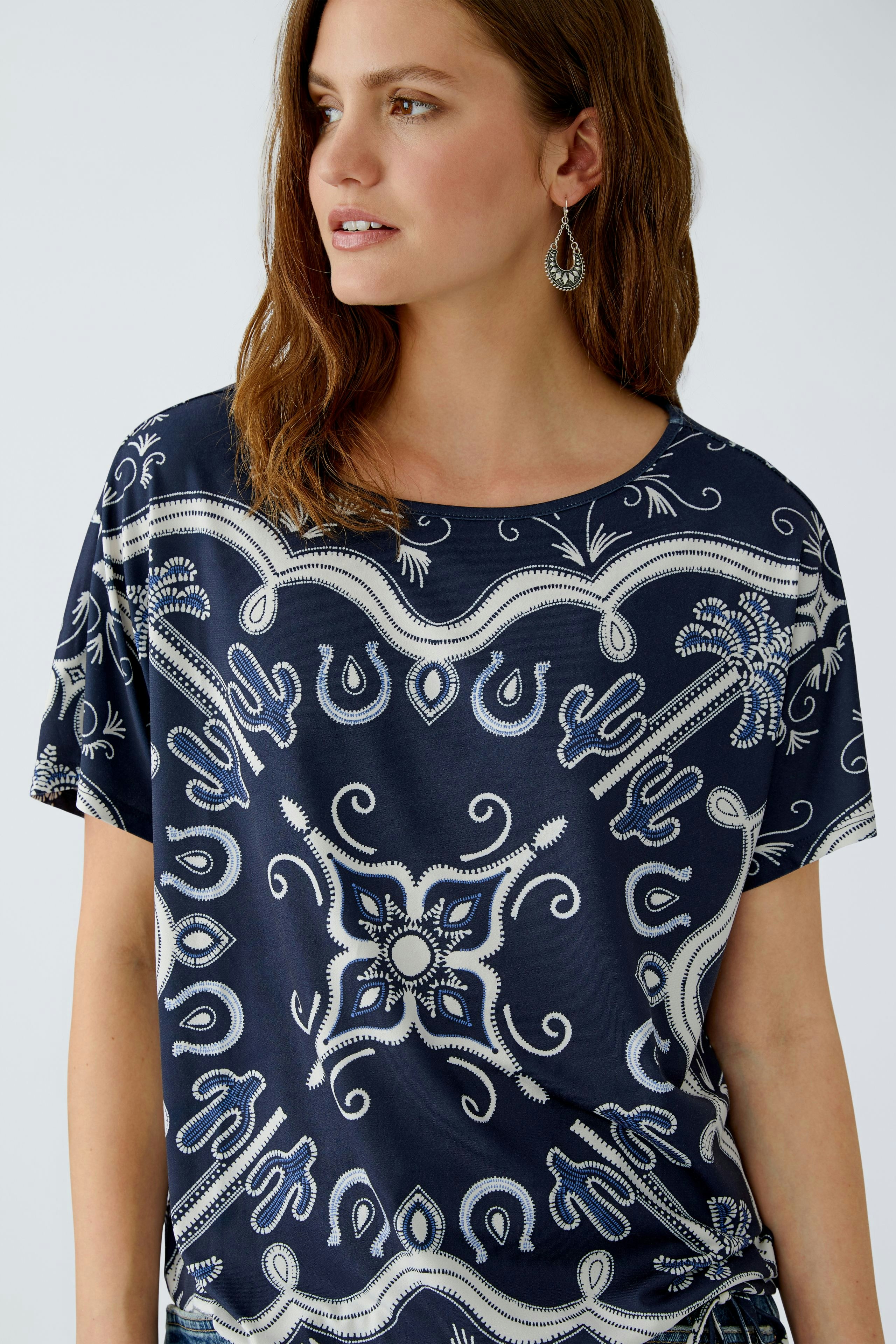 Casual women's T-shirt: Woman in a navy patterned top with a relaxed fit and round neckline.