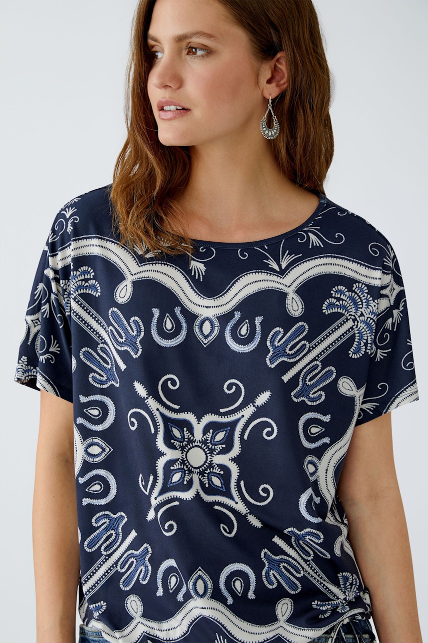 Casual women's T-shirt: Woman in a navy patterned top with a relaxed fit and round neckline.
