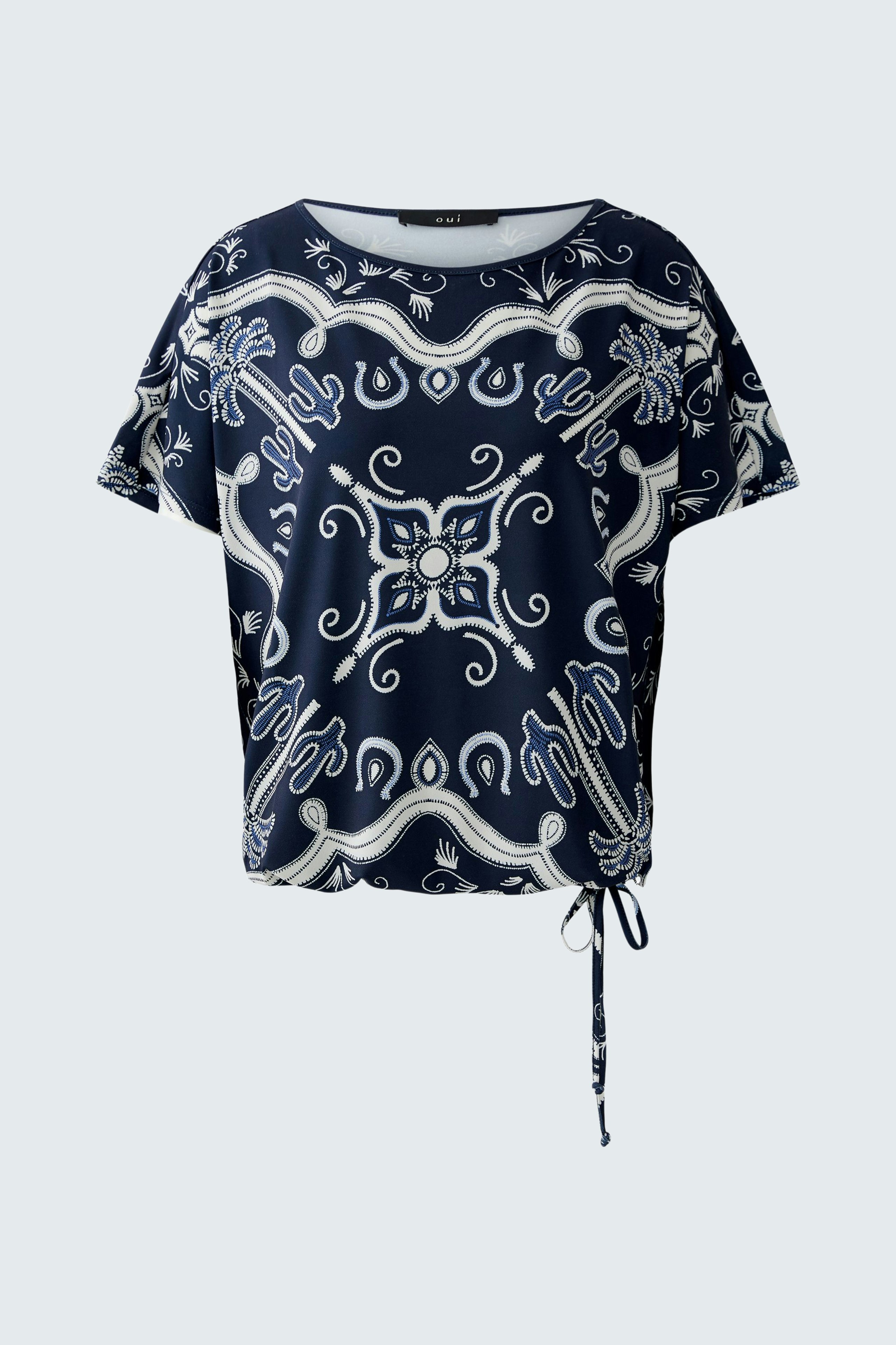 Casual women's T-shirt: A woman in a navy patterned top with a tie detail, showcasing a relaxed style.
