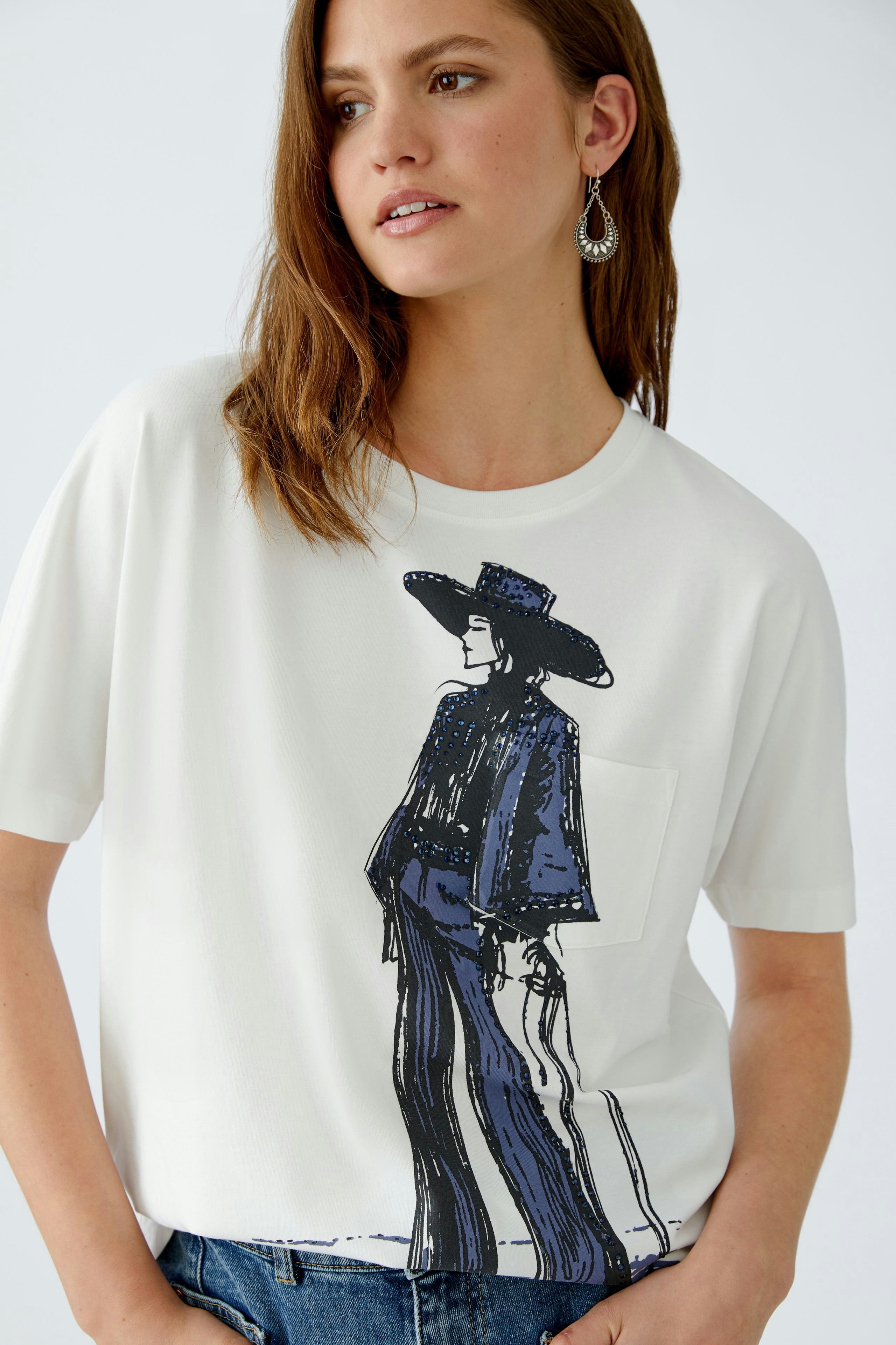 Damen-T-Shirt: Frau in weißem Shirt mit stylischem Druck und lässigem Schnitt.