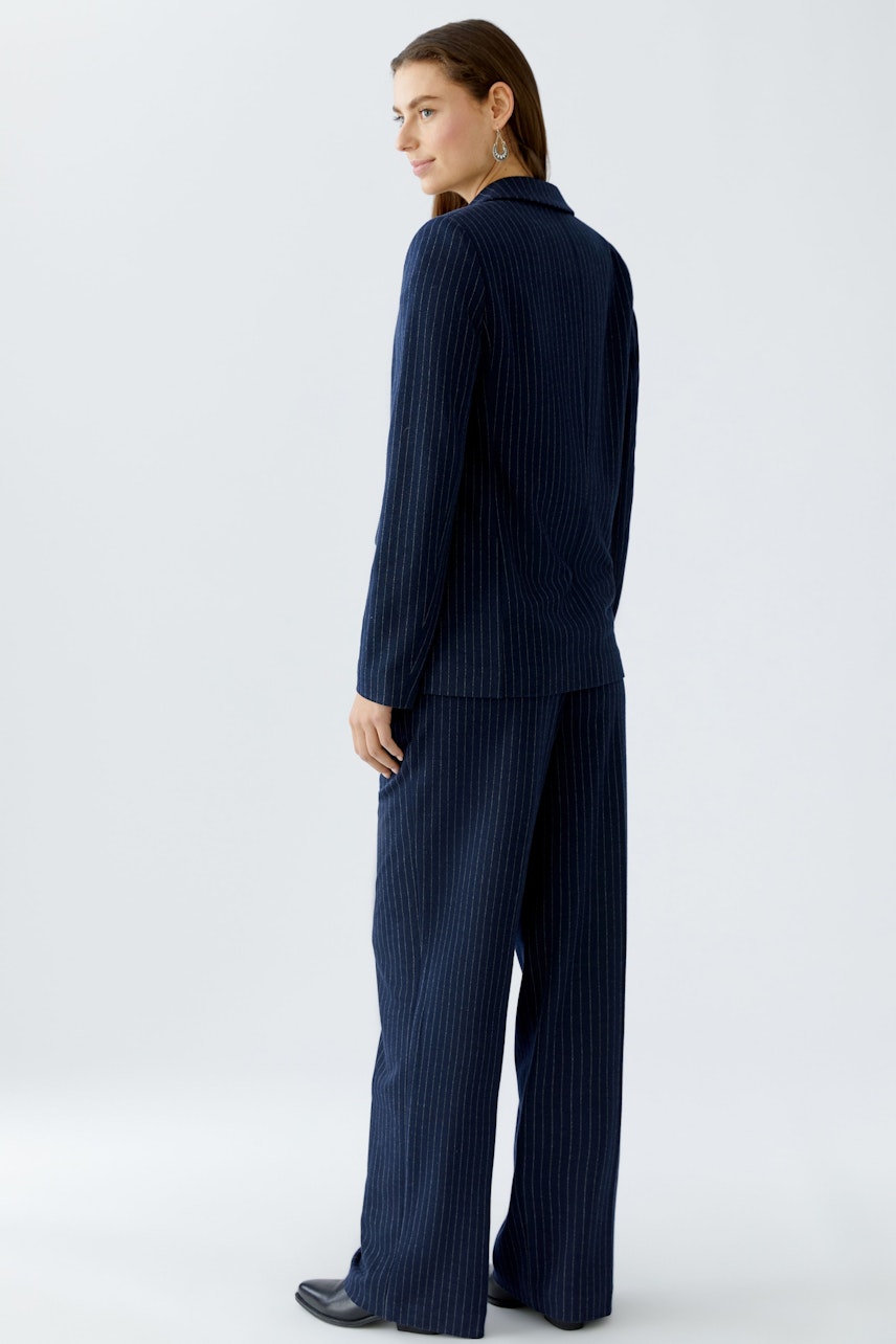 Stylish women's blazer: A woman in a navy pinstripe blazer, showcasing a modern and relaxed fit.