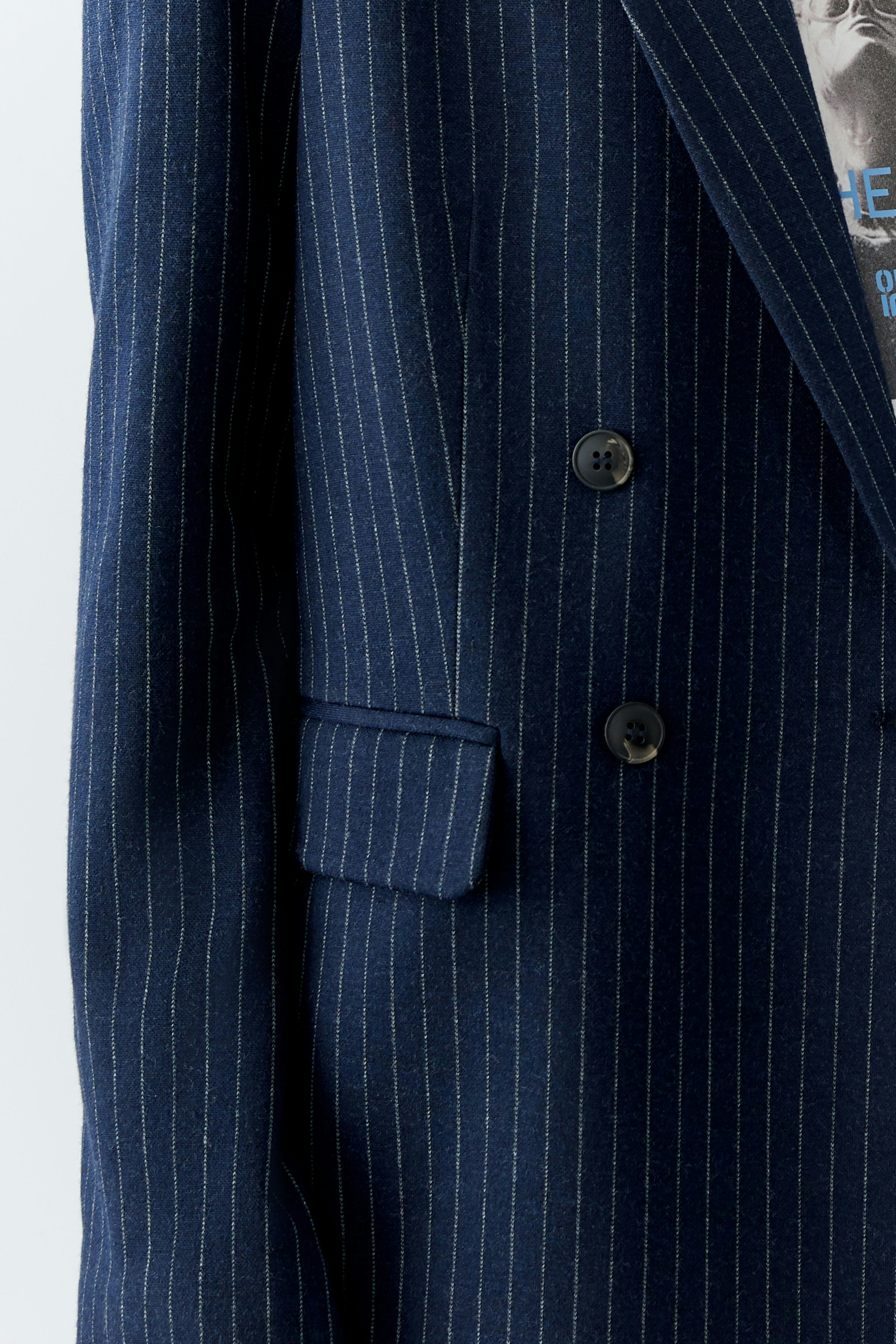 Stylish women's blazer in navy with pinstripes, featuring a double-breasted design and pockets.