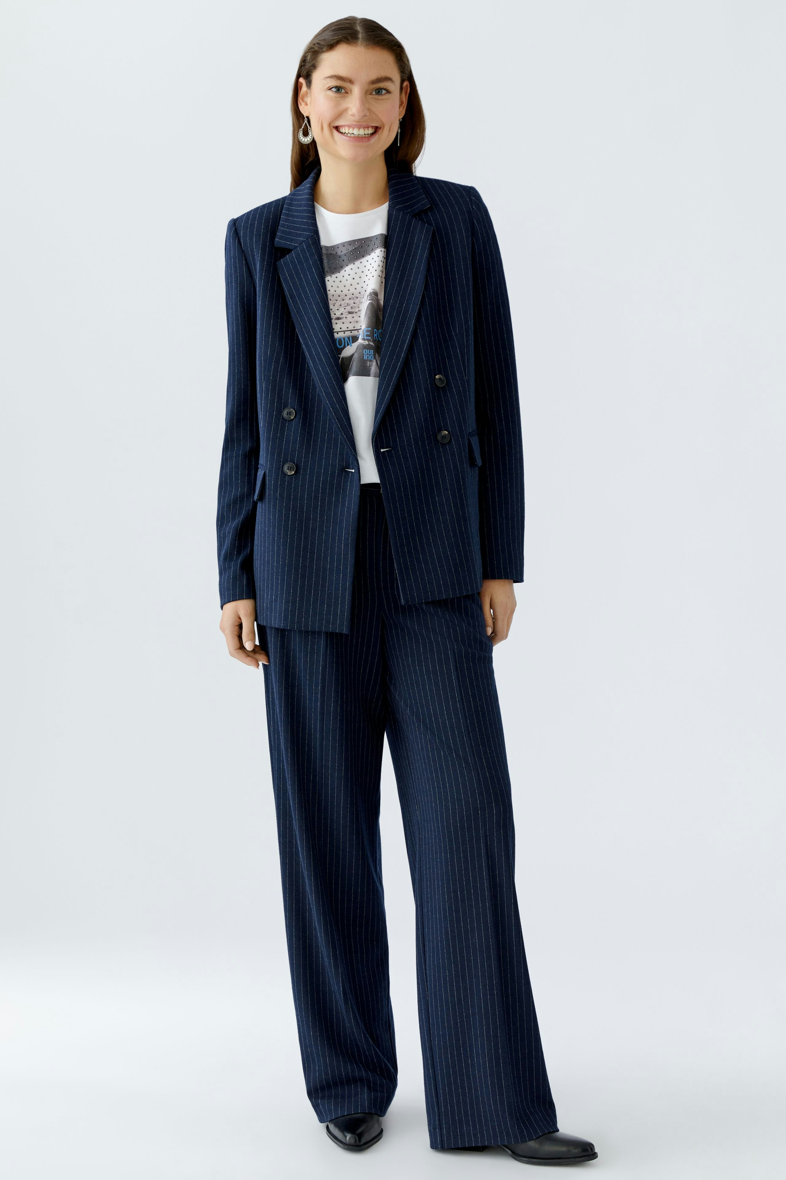 Stylish women's blazer: A woman in a navy pinstripe blazer paired with matching trousers.