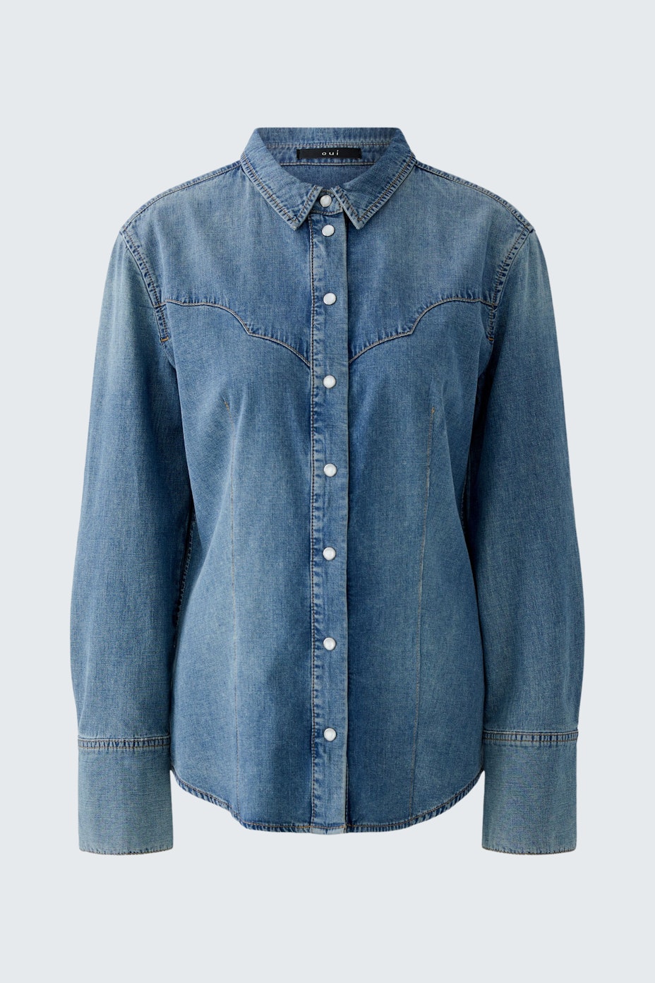 Casual women's denim shirt: A woman in a blue denim shirt with button closure and long sleeves.