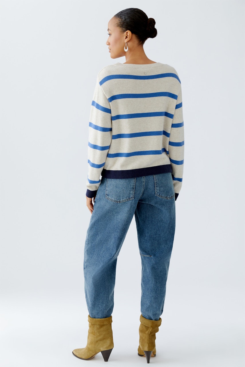 Damen-Pullover: Frau mit gestreiftem Pullover in Beige und Blau, kombiniert mit lässigen Jeans.