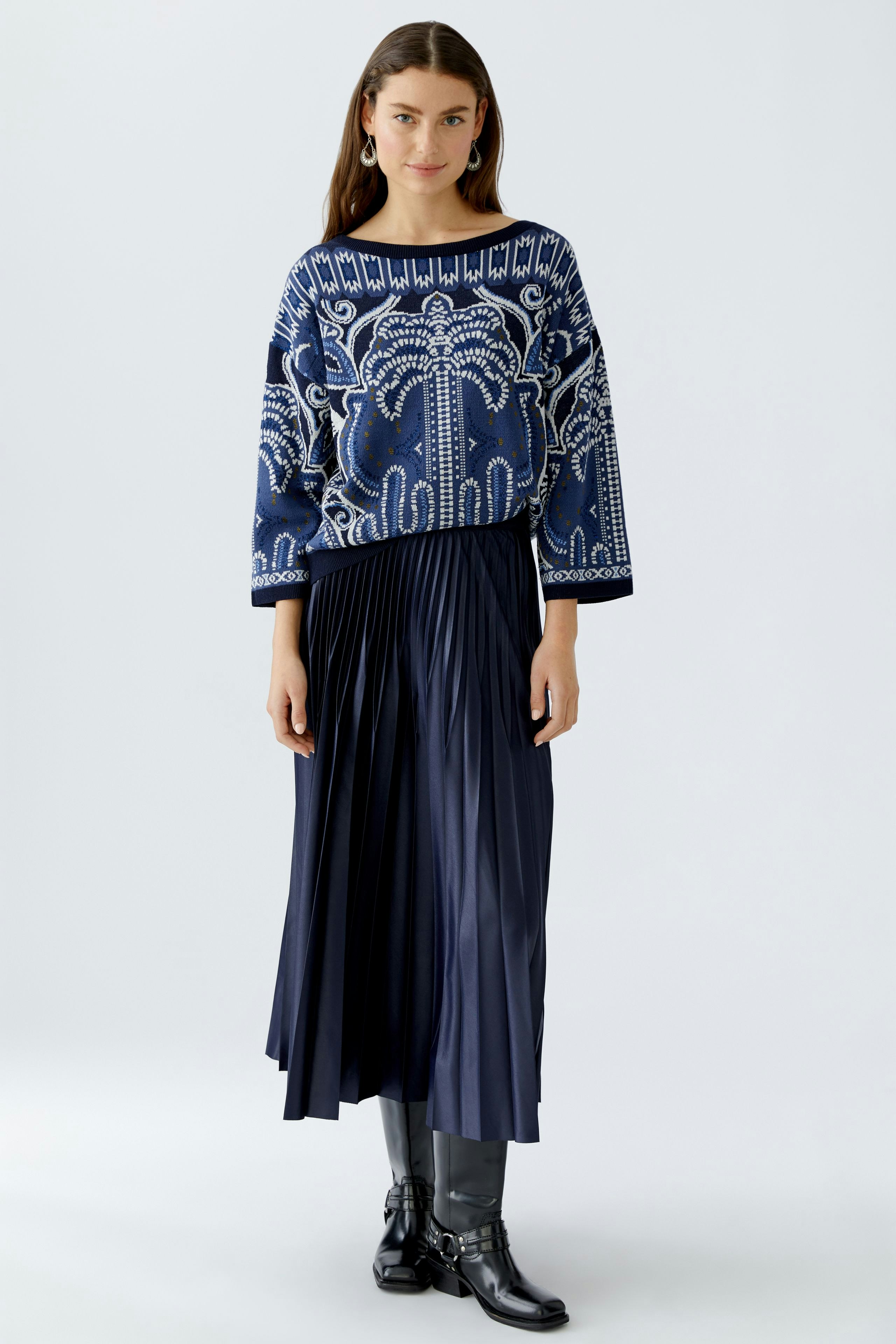 Damen-Pullover: Junge Frau in blauem, gemustertem Pullover mit weitem Schnitt und lässigem Look.