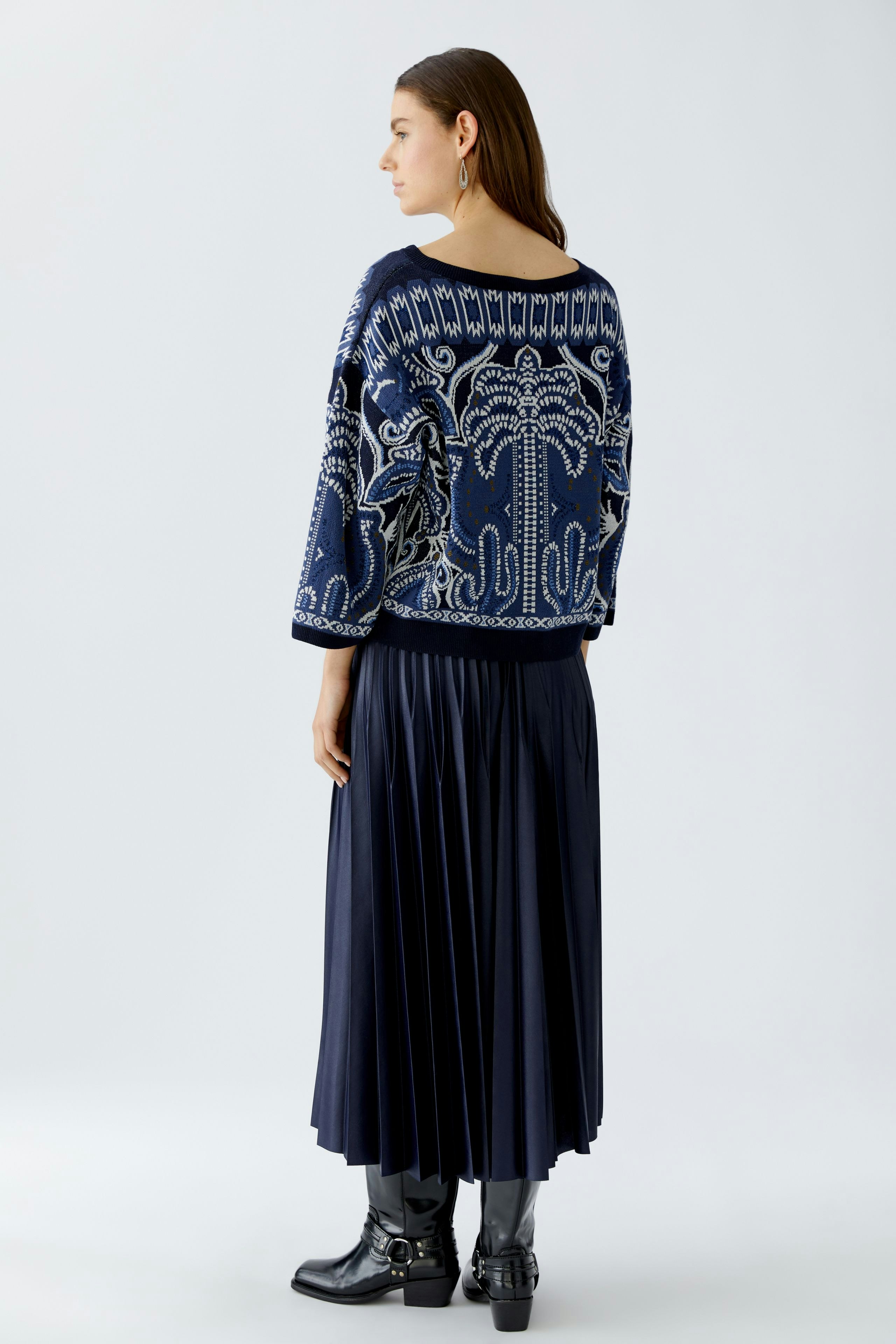 Damen-Pullover: Frau in blauem, gemustertem Pullover mit weitem Schnitt und lässiger Rock.