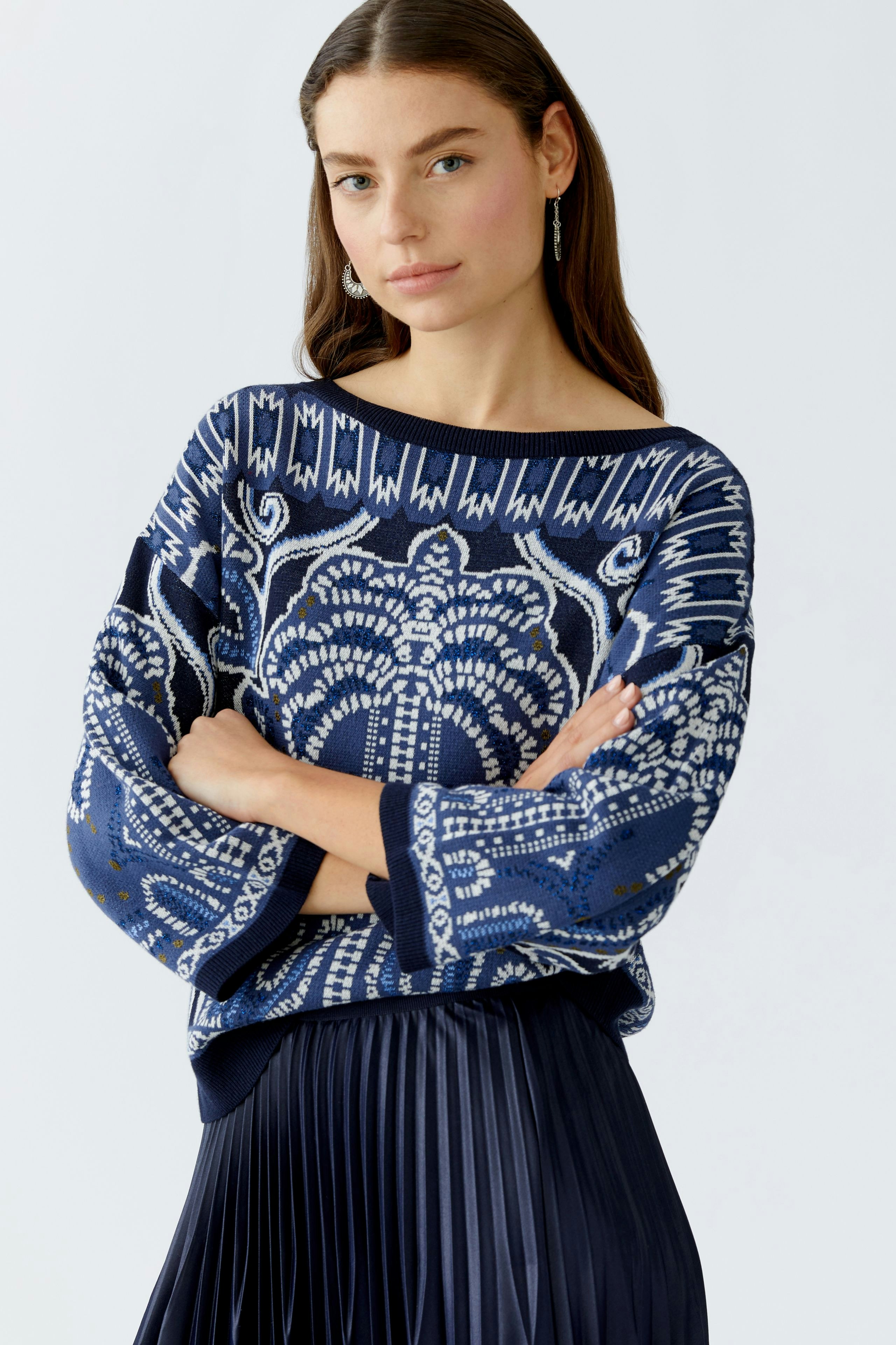 Damen-Pullover: Frau in blauem, gemustertem Pullover mit weitem Schnitt und lässigem Look.