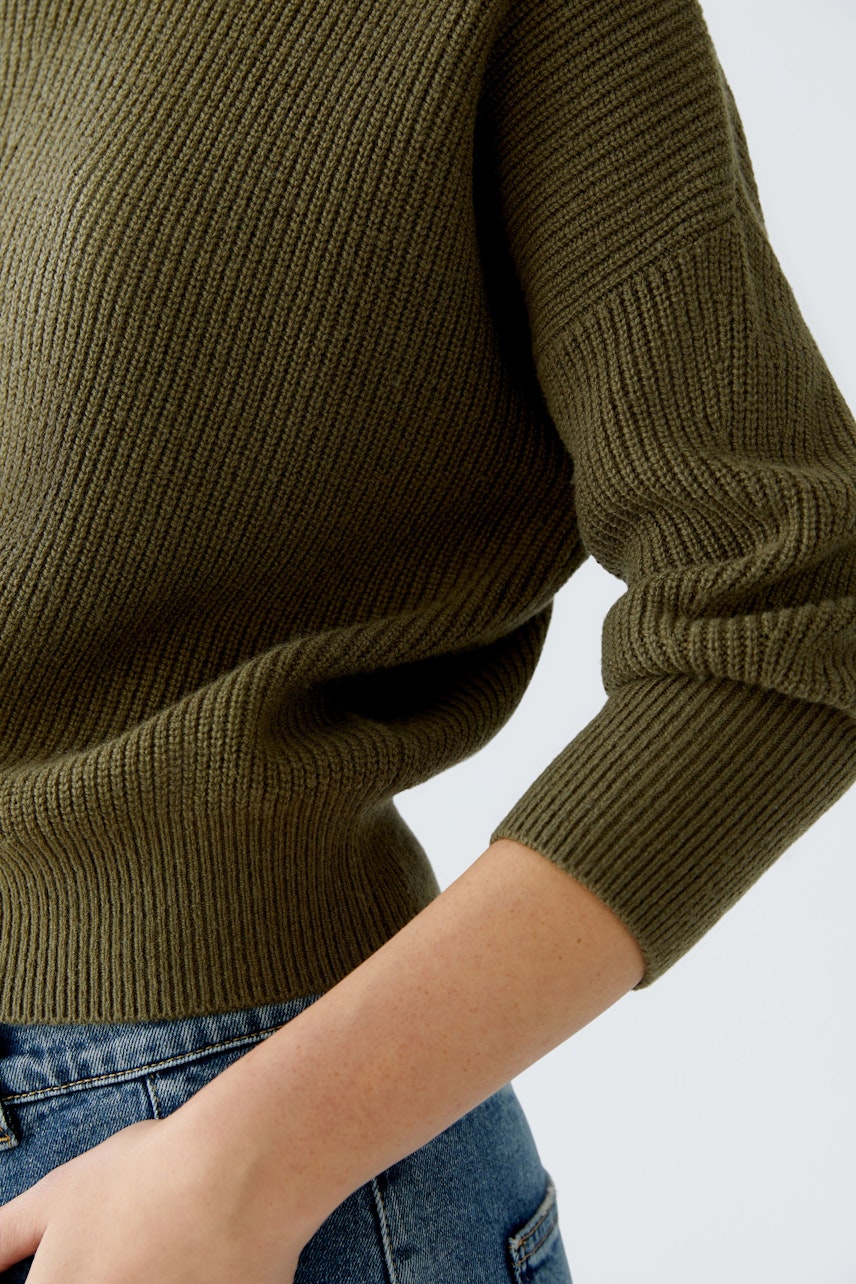 Damen-Pullover in Olivgrün: Frau trägt einen lässigen, strukturierten Pullover mit 3/4-Ärmeln.