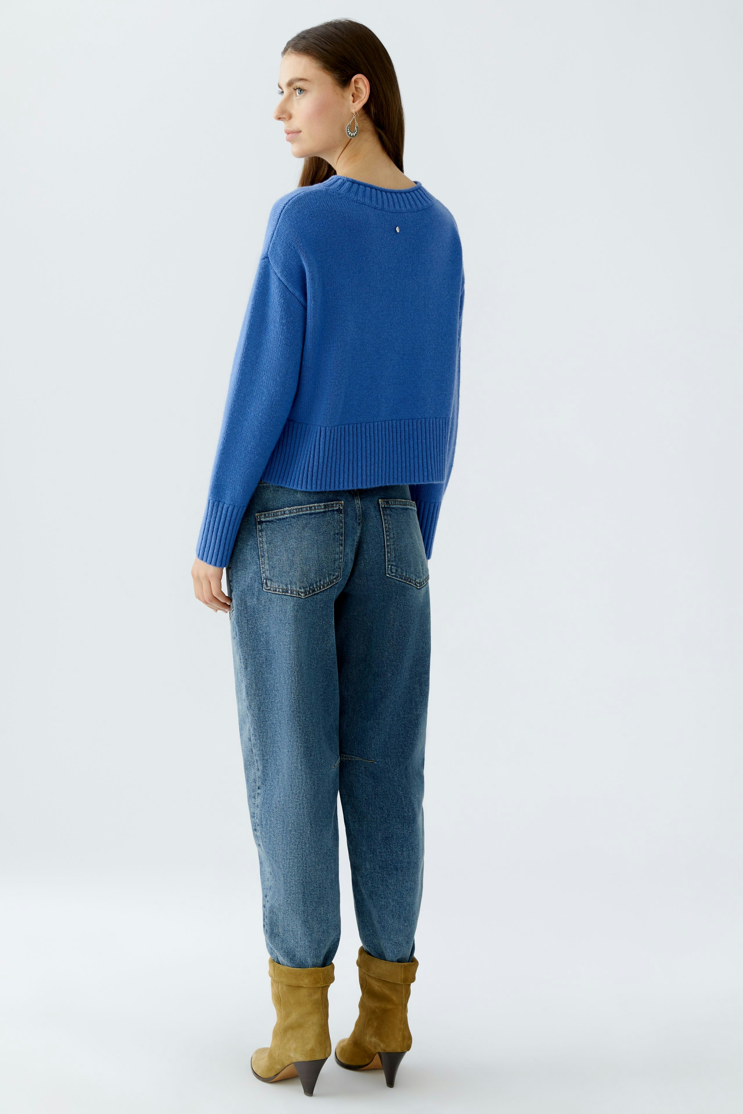Casual women's pullover: A woman in a blue pullover paired with relaxed jeans, showcasing a laid-back style.