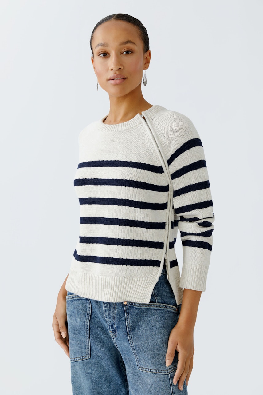 Damen-Pullover: Frau in gestreiftem Pullover mit seitlichem Schlitz und lässigen Jeans.