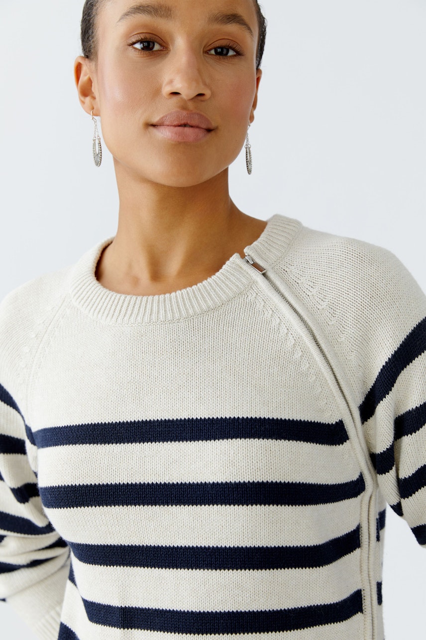 Damen-Pullover: Frau trägt einen gestreiften Pullover in Creme und Marineblau mit Reißverschluss.