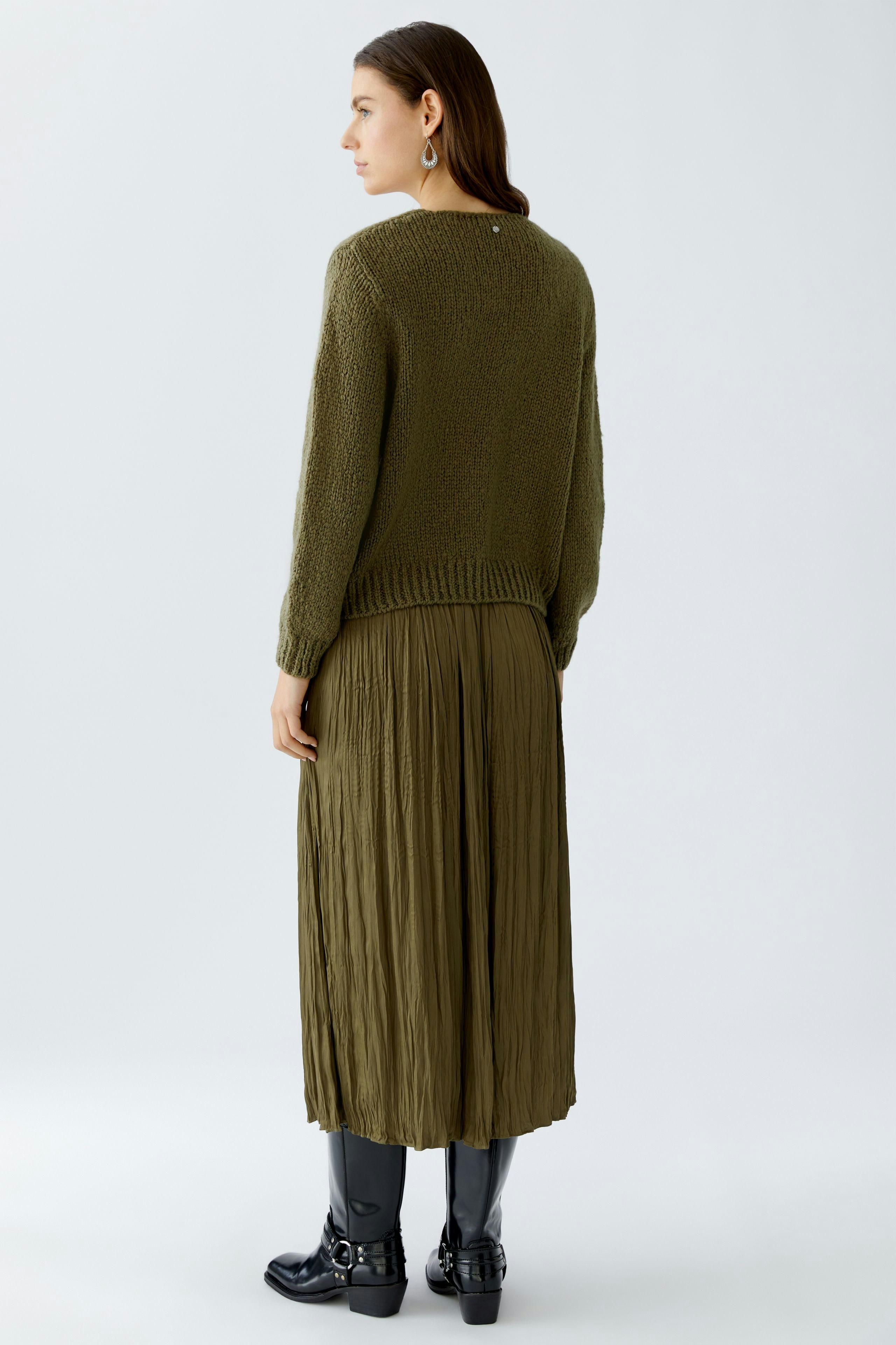 Casual women's pullover: A woman in a cozy green pullover paired with a flowing skirt.
