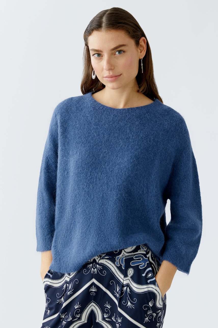 Damen-Pullover in Blau: Junge Frau trägt einen lässigen, weichen Pullover mit Rundhalsausschnitt.