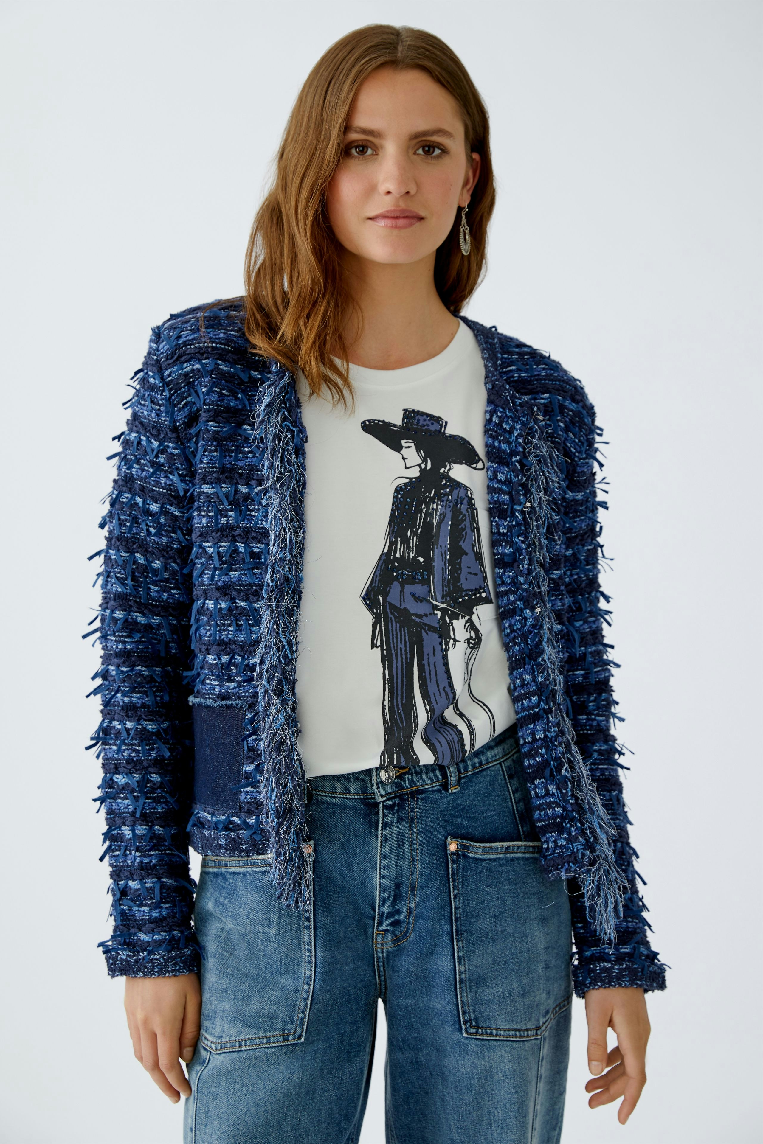 Casual women's cardigan: A woman in a blue textured cardigan over a graphic tee and jeans.