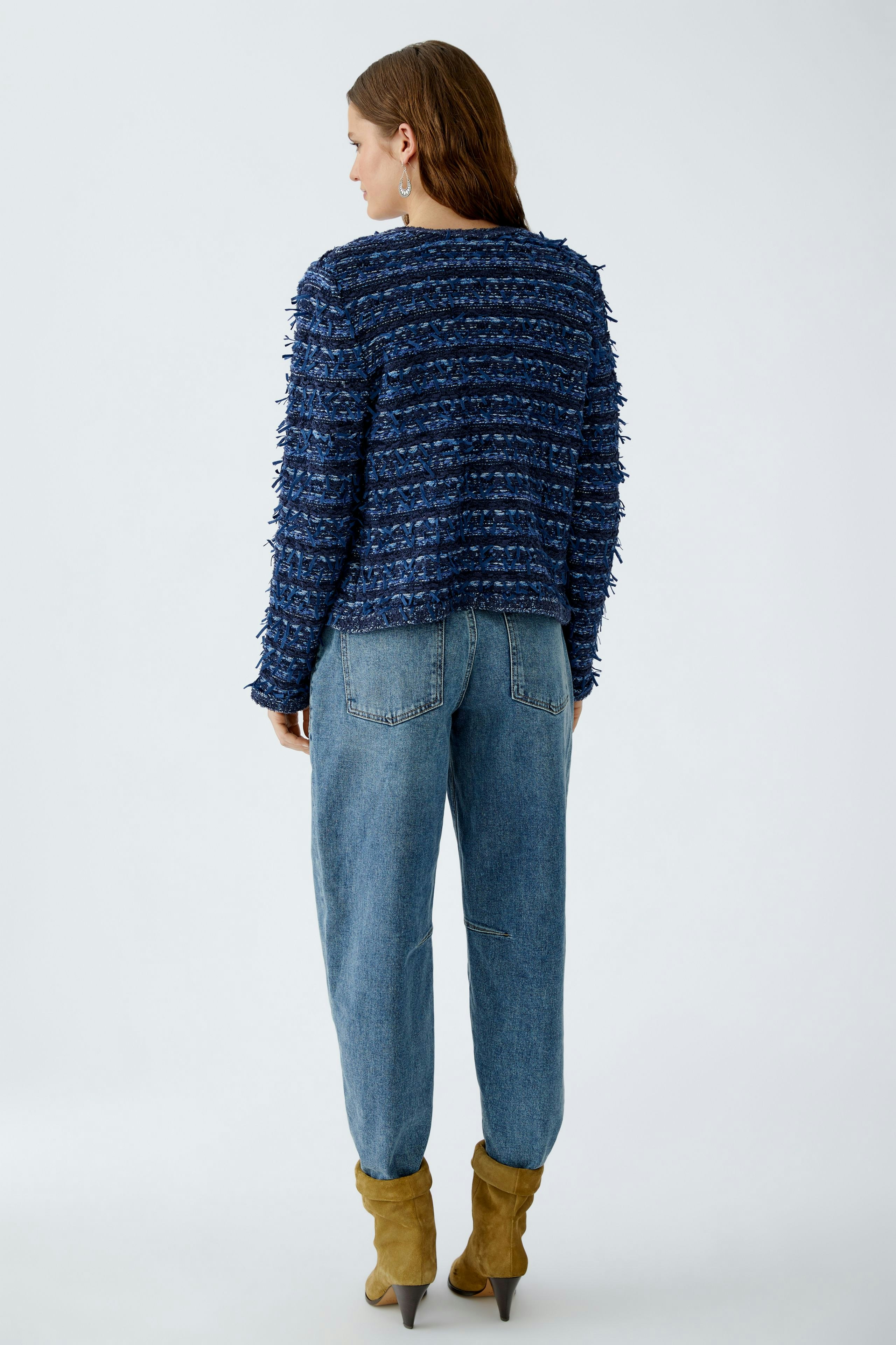 Casual women's cardigan: A woman in a textured navy cardigan paired with relaxed jeans.