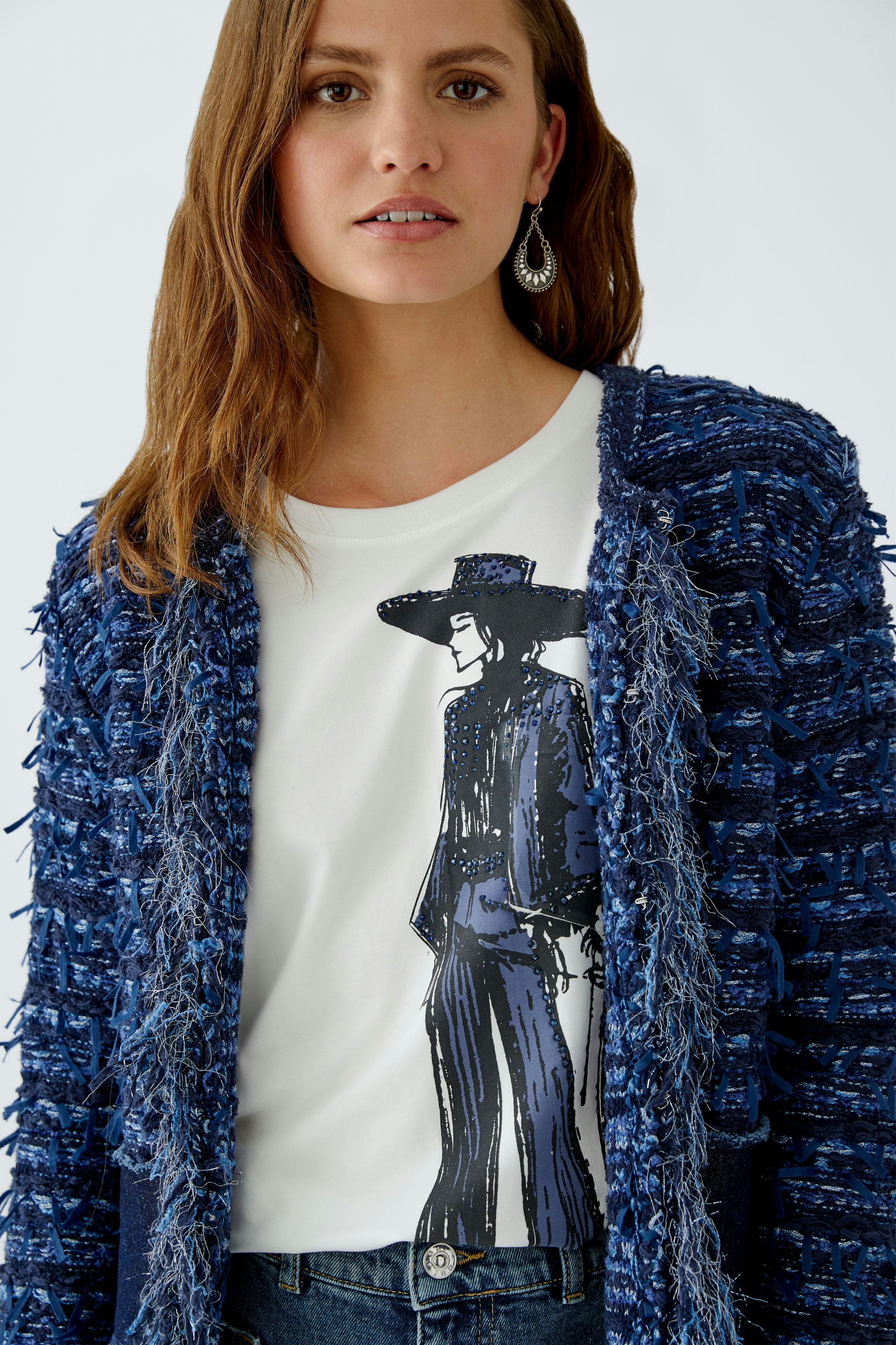 Casual women's cardigan: A woman in a blue textured cardigan over a graphic tee, looking confidently.