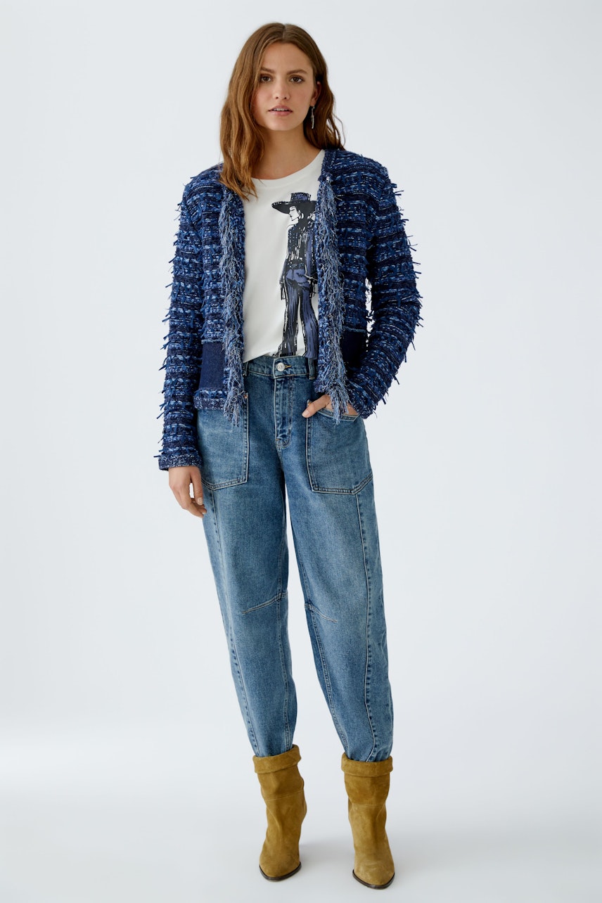 Damen-Strickjacke: Frau in blauer Strickjacke mit lässigem T-Shirt und Jeans, kombiniert mit Stiefeln.