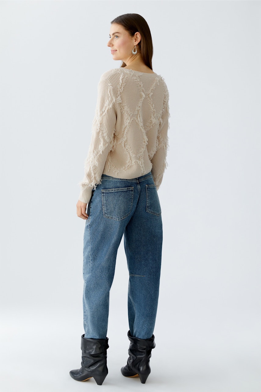 Damen-Pullover: Frau in beigem Strickpullover mit lässigem Schnitt und lockerer Passform.