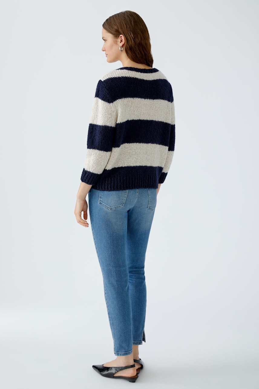 Casual women's pullover: A woman in a striped pullover with navy and cream colors, styled with jeans.