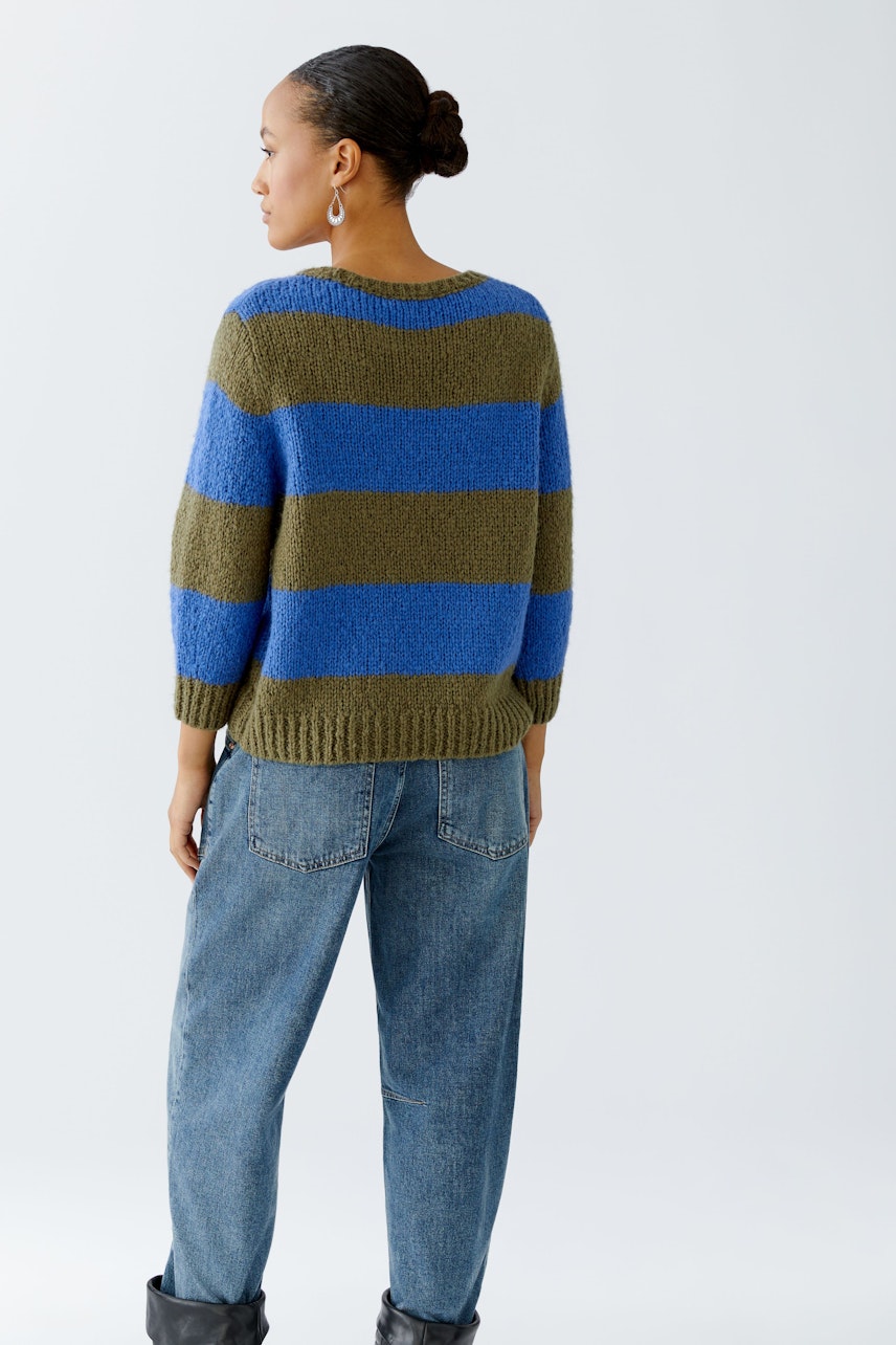 Casual women's pullover: A woman in a blue and green striped pullover with a relaxed fit.