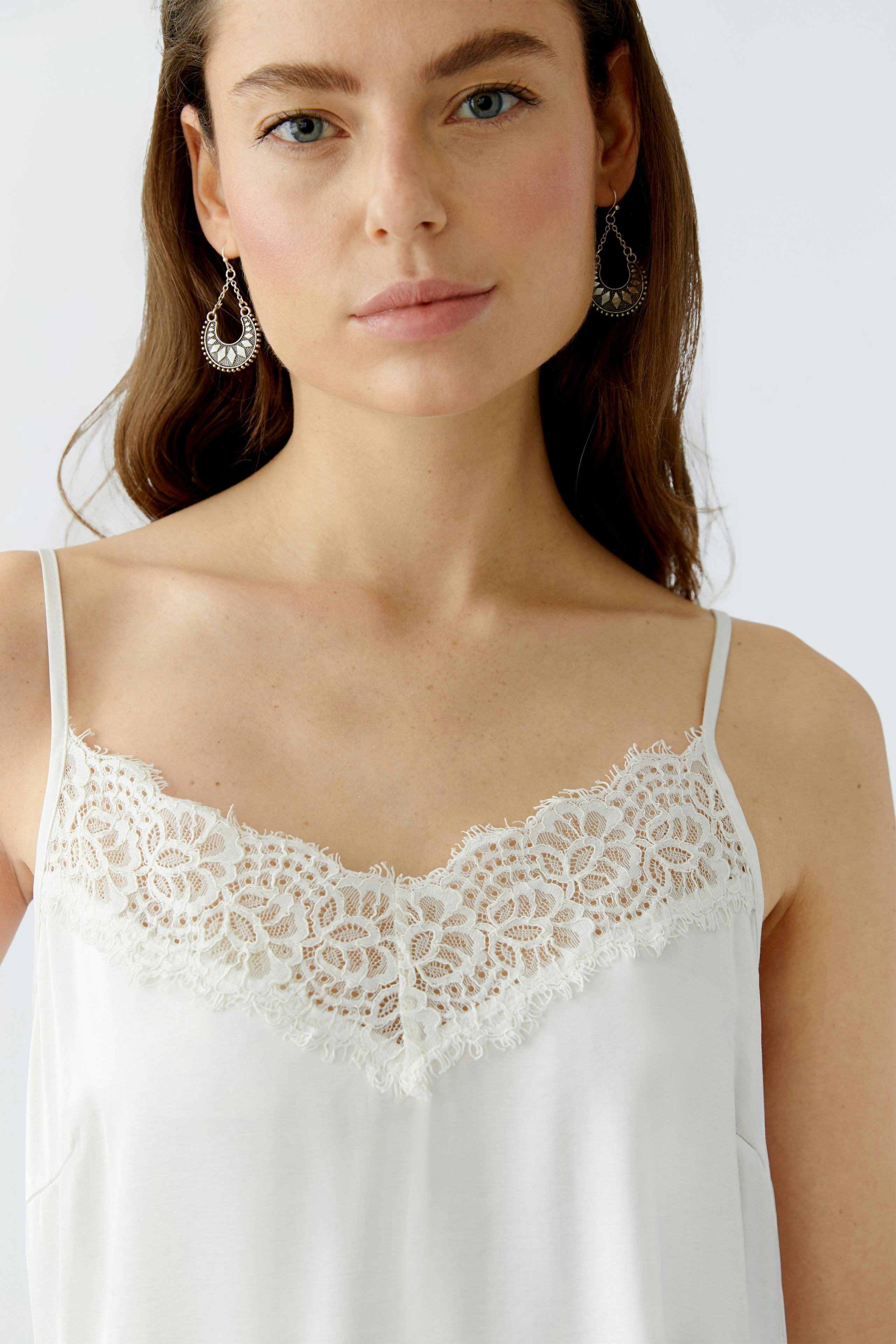 Lightweight women's top with lace detailing, featuring a relaxed fit and adjustable straps.