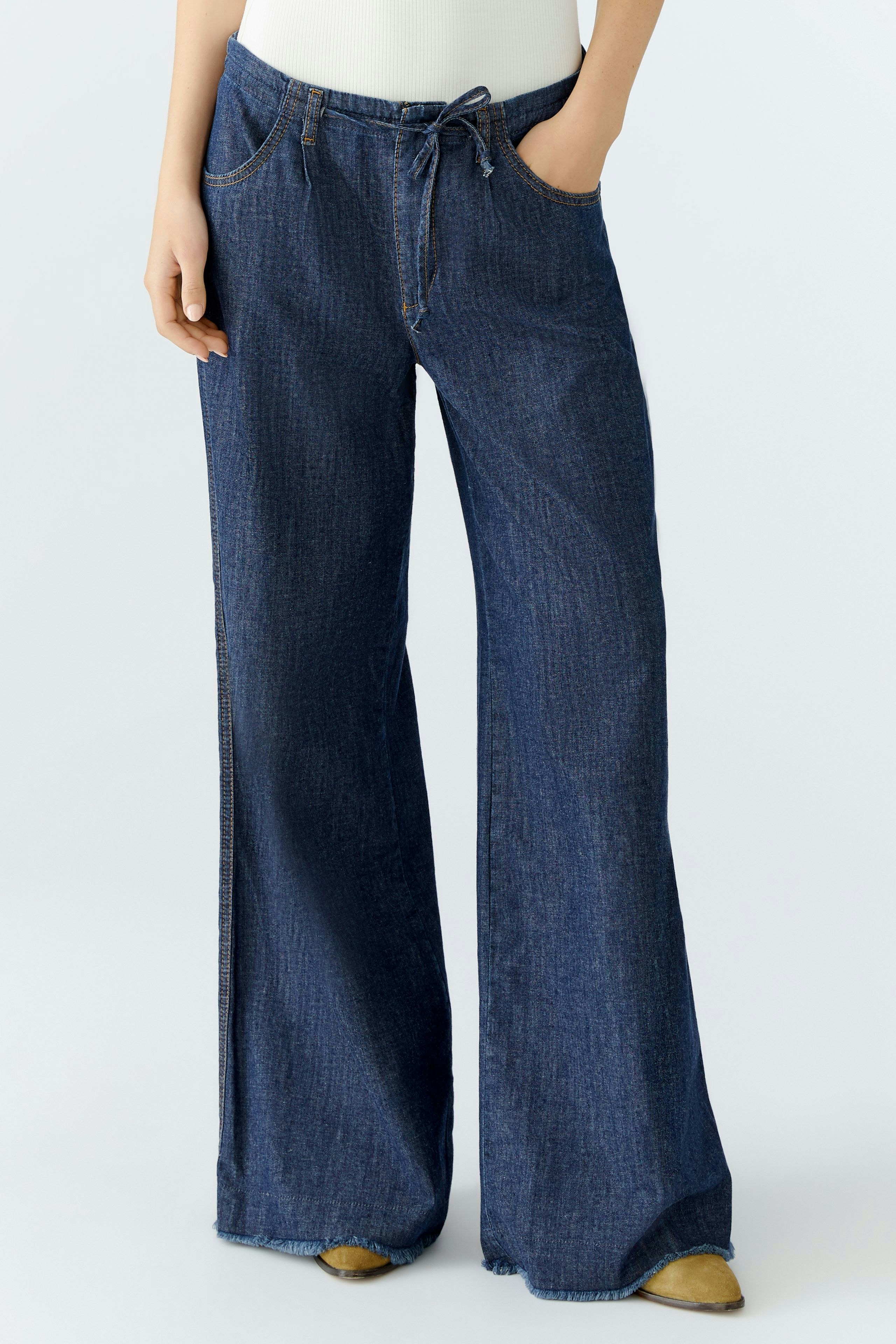 Wide leg jeans for women: A woman in dark blue wide leg jeans with a relaxed fit.