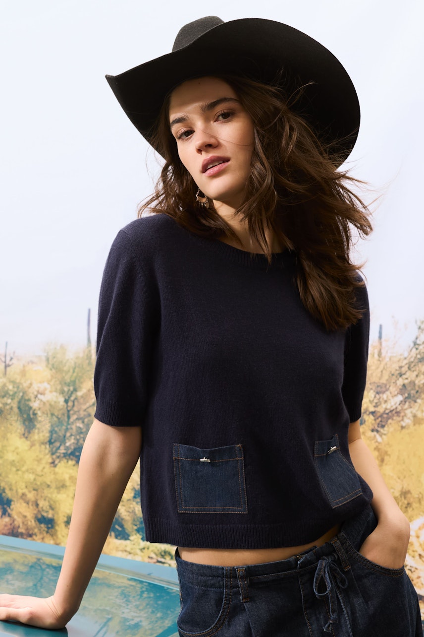 Casual wide leg jeans: Young woman in dark jeans with pockets, styled with a relaxed look.