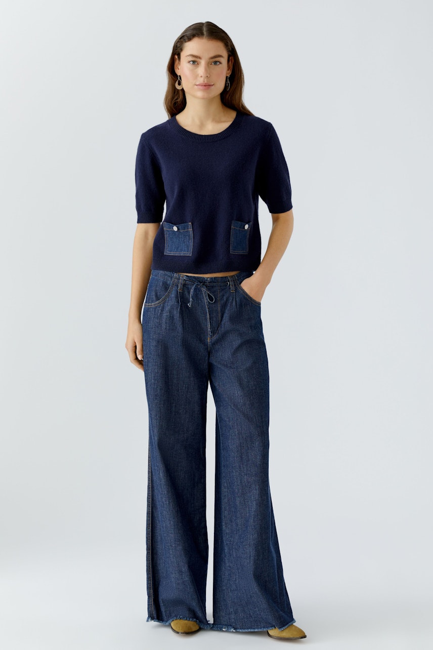 Wide leg jeans for women: A woman in dark blue wide leg jeans with a casual fit.