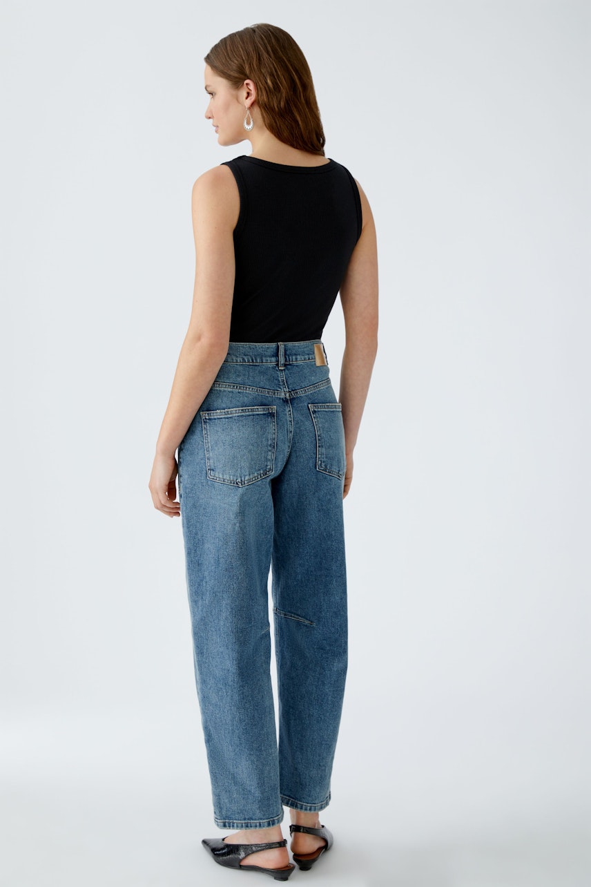 Casual women's jeans: A woman in blue barrel jeans with a relaxed fit, showcasing a simple and stylish look.