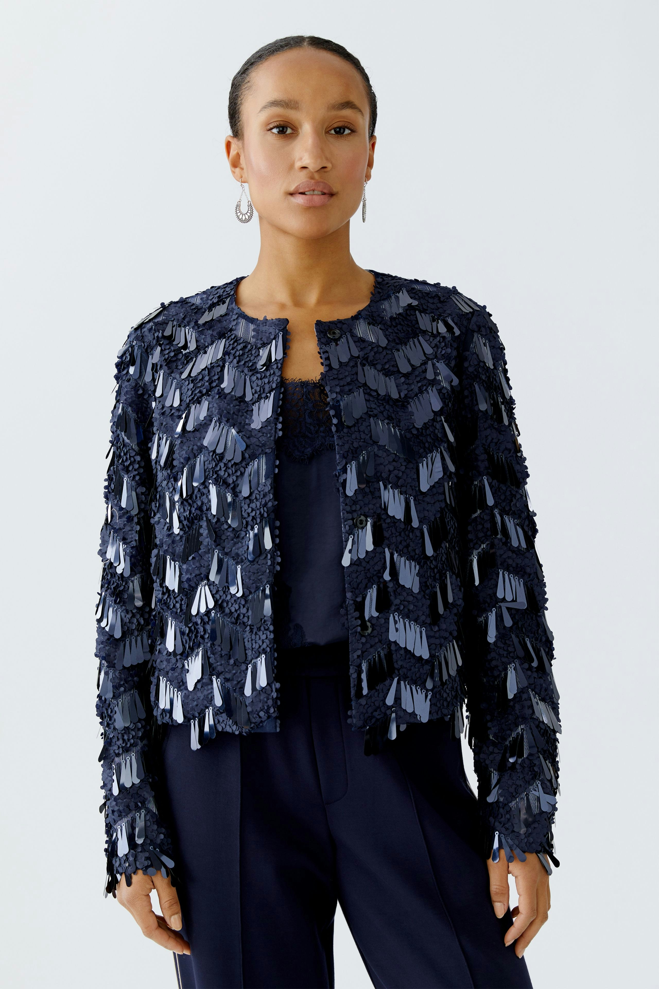 Stylish women's jacket: A woman in a navy jacket with textured detailing, paired with a simple top.