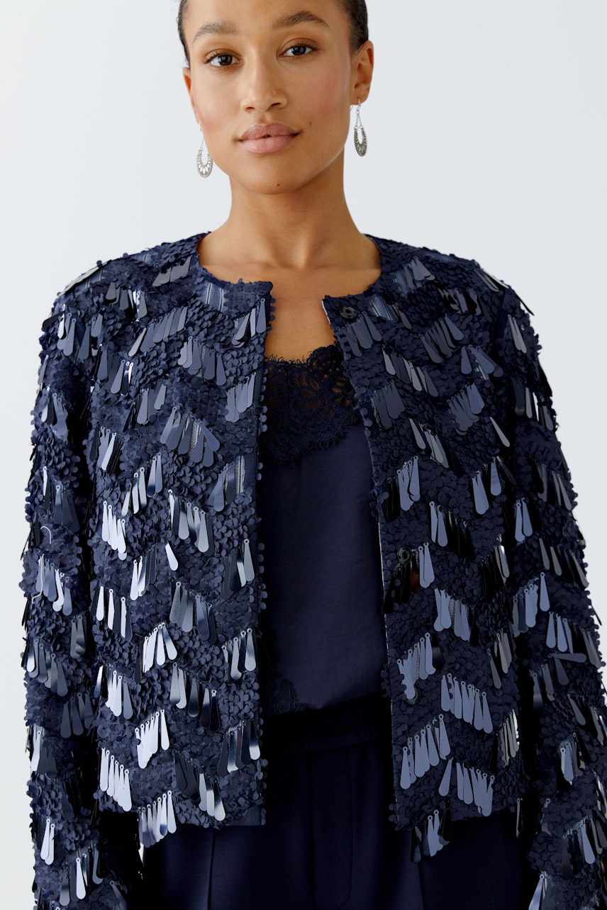 Stylish women's jacket: A woman in a navy jacket with textured detailing, perfect for casual outings.