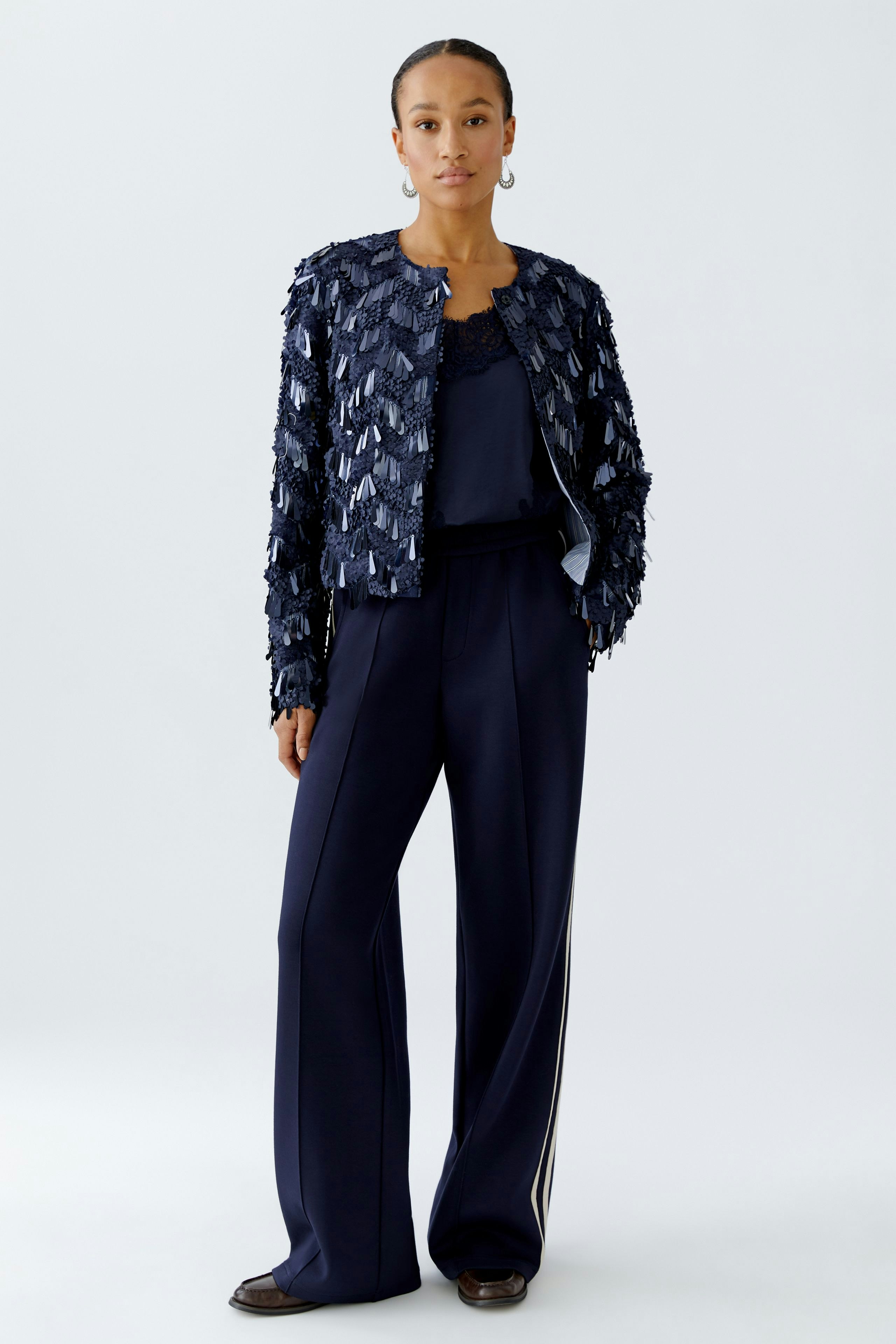 Stylish women's jacket: A woman in a textured navy jacket paired with relaxed trousers.