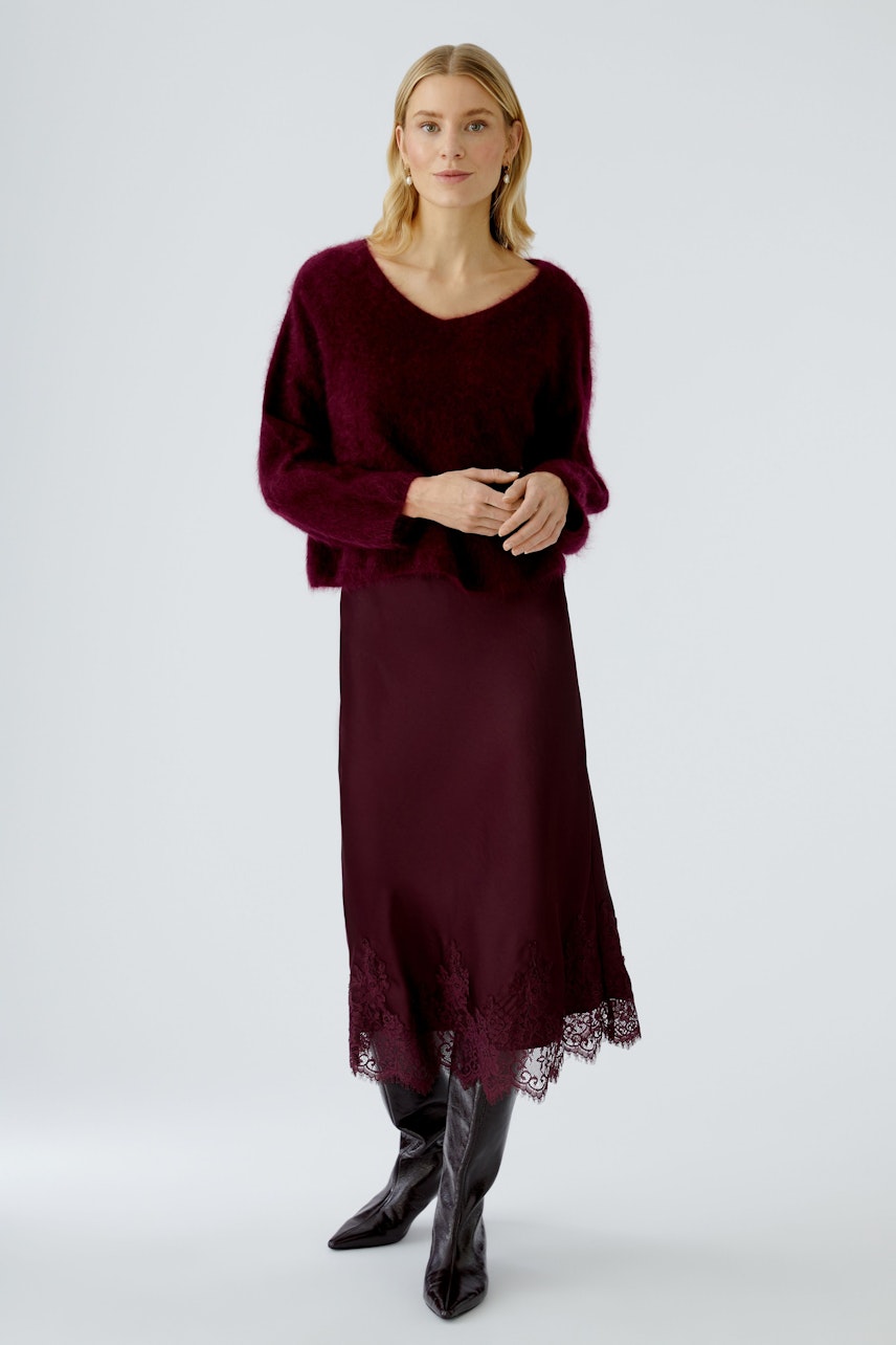 A-line skirt: A woman in a burgundy skirt with lace detailing, showcasing a relaxed style.