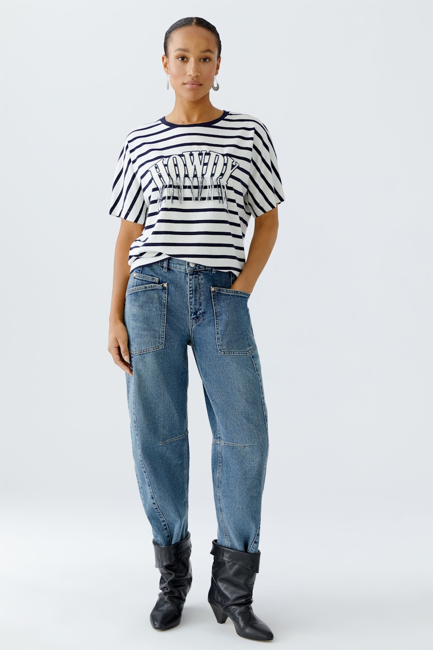 Lässiges Damen-T-Shirt: Frau in gestreiftem Shirt mit Schriftzug und lockeren Jeans.