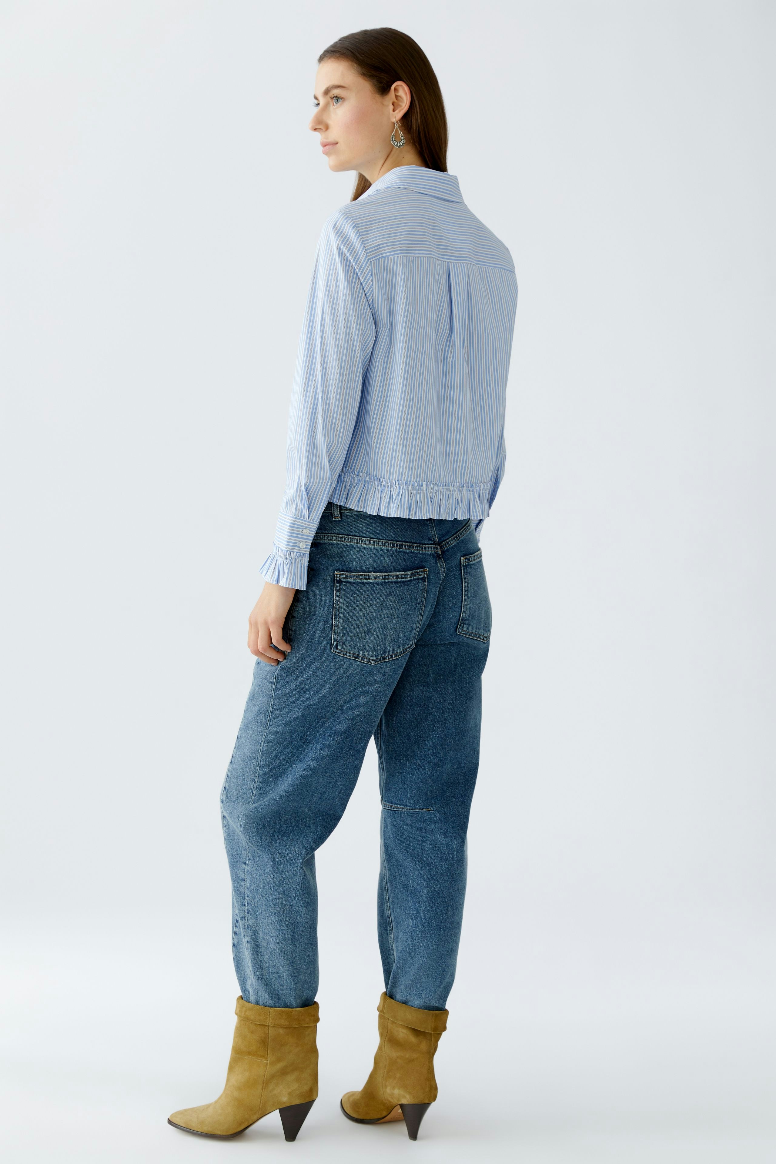 Casual women's blouse: Woman in a light blue striped blouse with a relaxed fit and elastic hem.