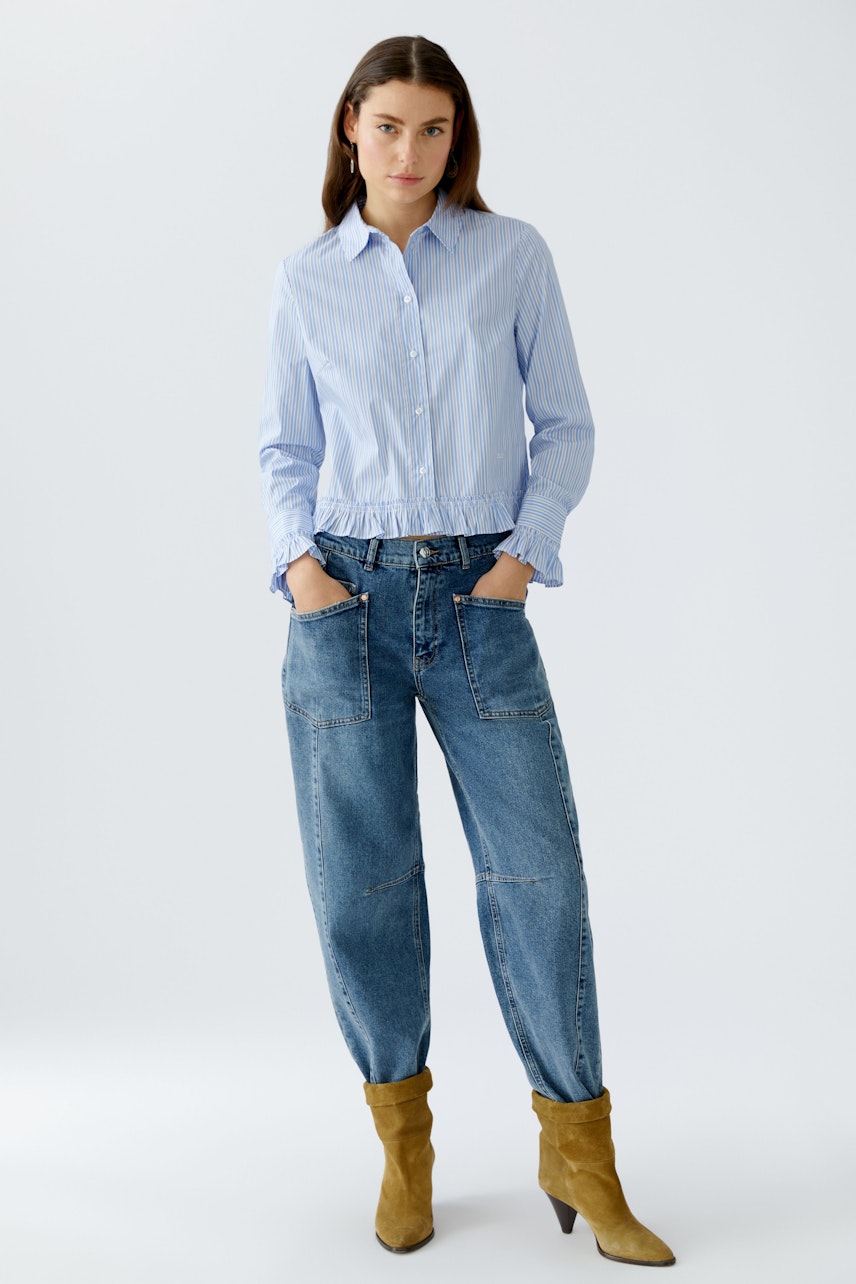 Casual women's blouse: A woman in a light blue striped blouse with a gathered hem and relaxed fit.