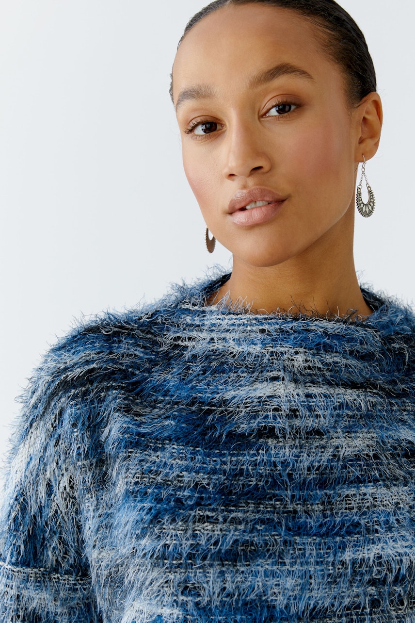 Casual women's pullover: Young woman in a blue textured pullover with a relaxed fit.