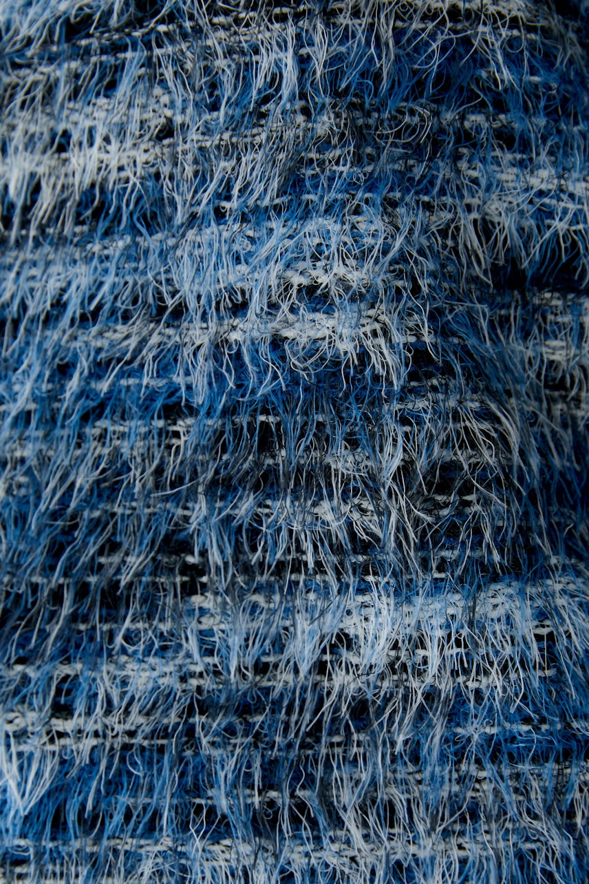 Textured blue pullover: Close-up of a women's pullover with a unique, fuzzy design in various blue shades.