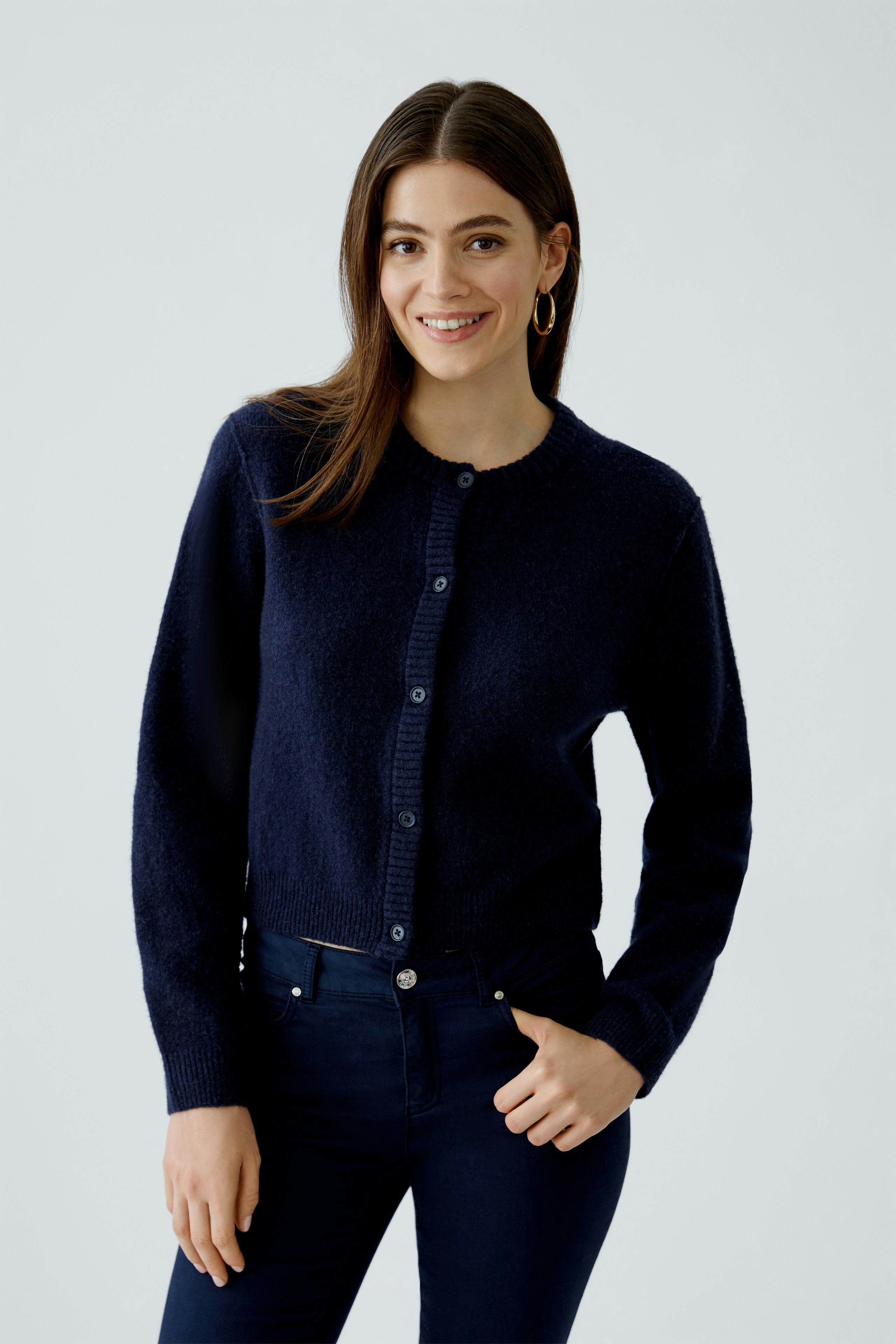 Casual women's cardigan: A woman in a navy cardigan with buttons and a relaxed fit smiles confidently.