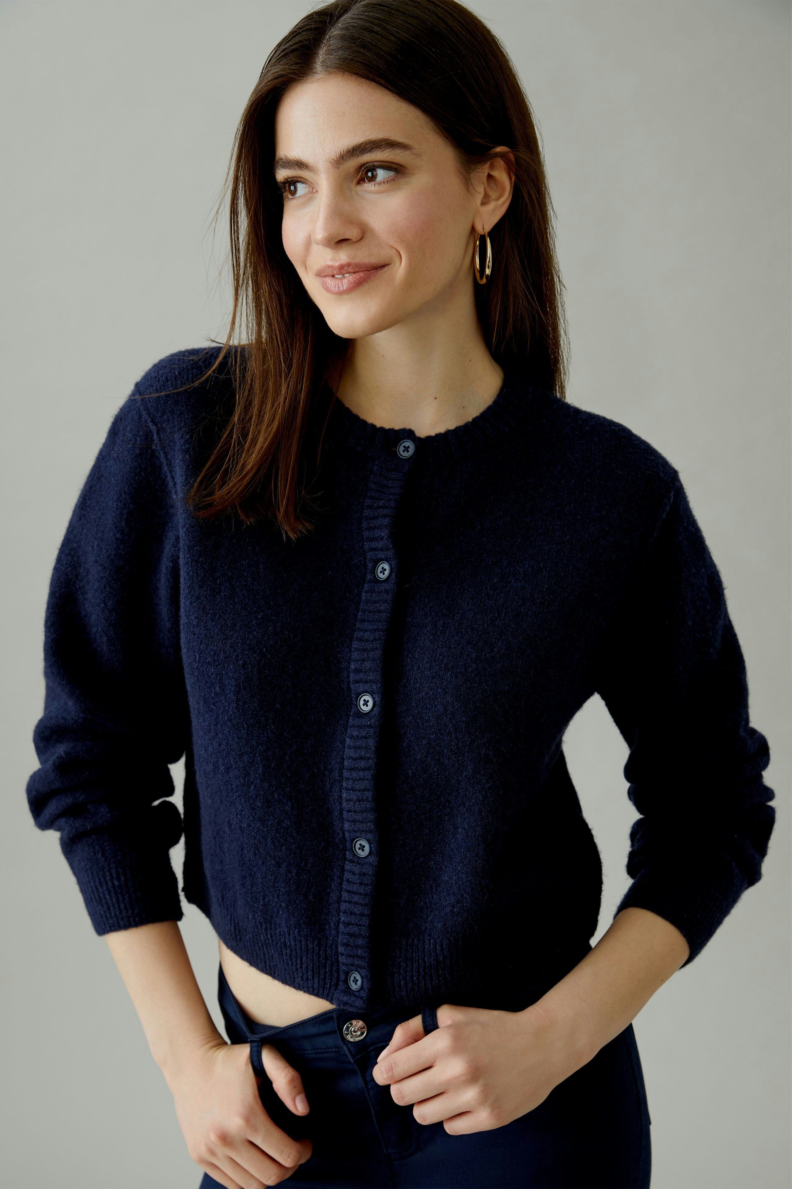 Casual women's cardigan: A woman in a navy blue cardigan with buttons, smiling confidently.