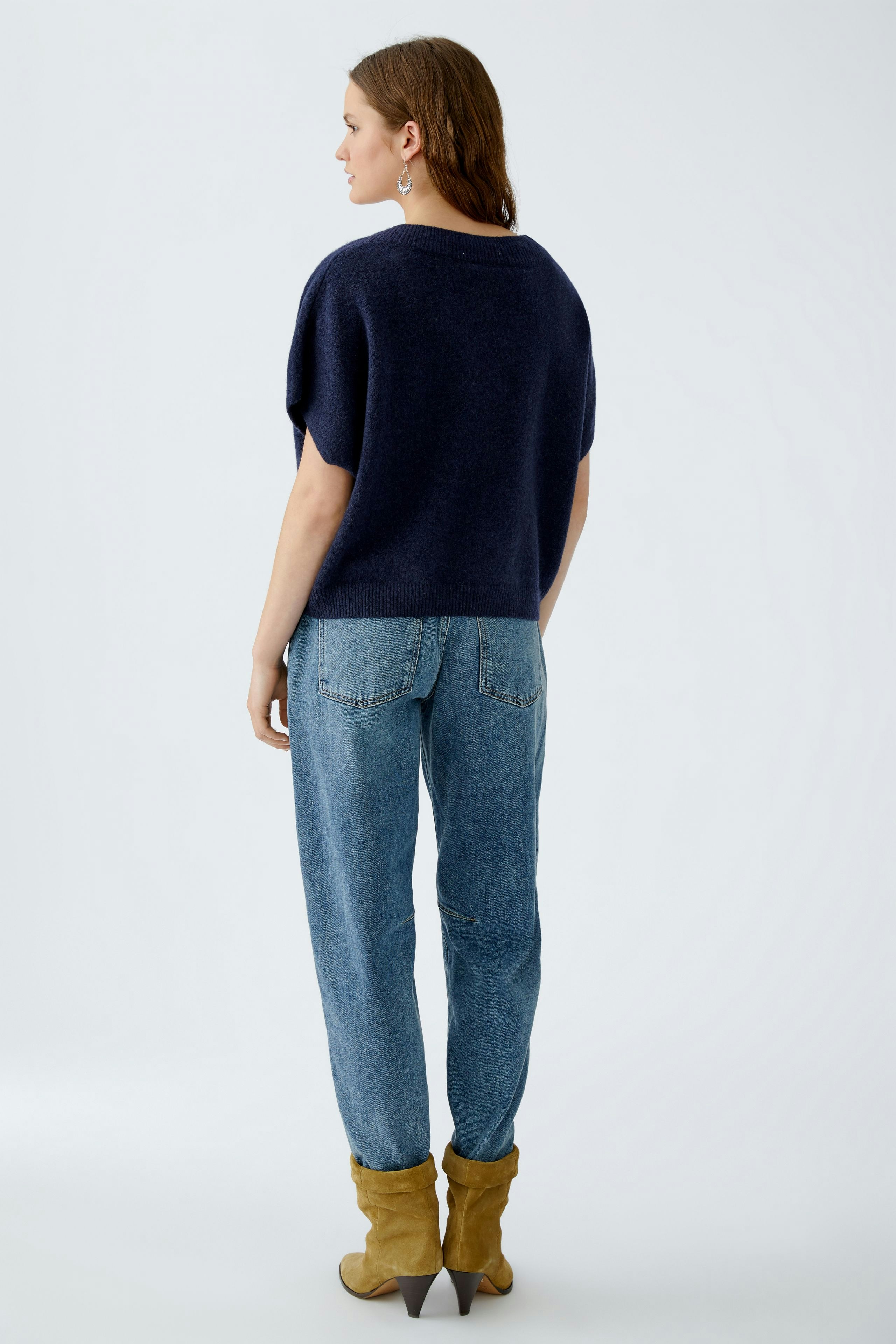 Casual women's pullover: A woman in a navy pullover paired with relaxed jeans and stylish boots.