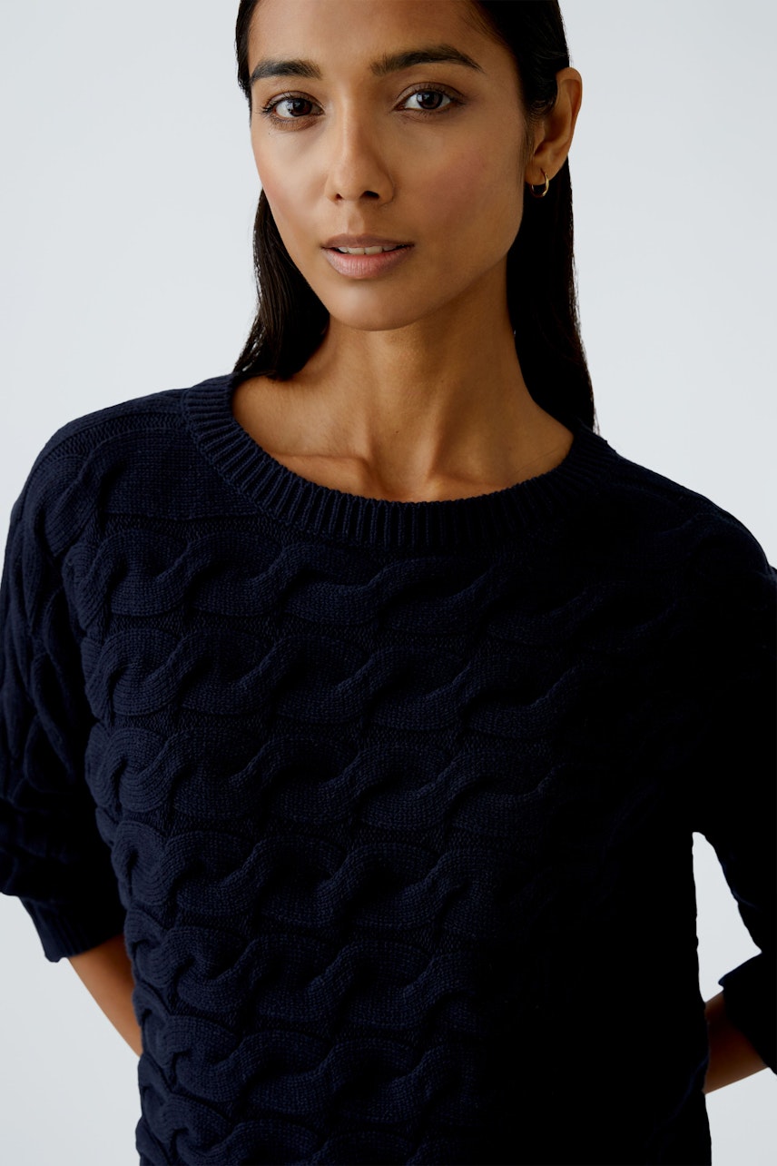 Damen-Pullover: Frau in dunkelblauem, strukturiertem Strickpullover mit Rundhalsausschnitt.