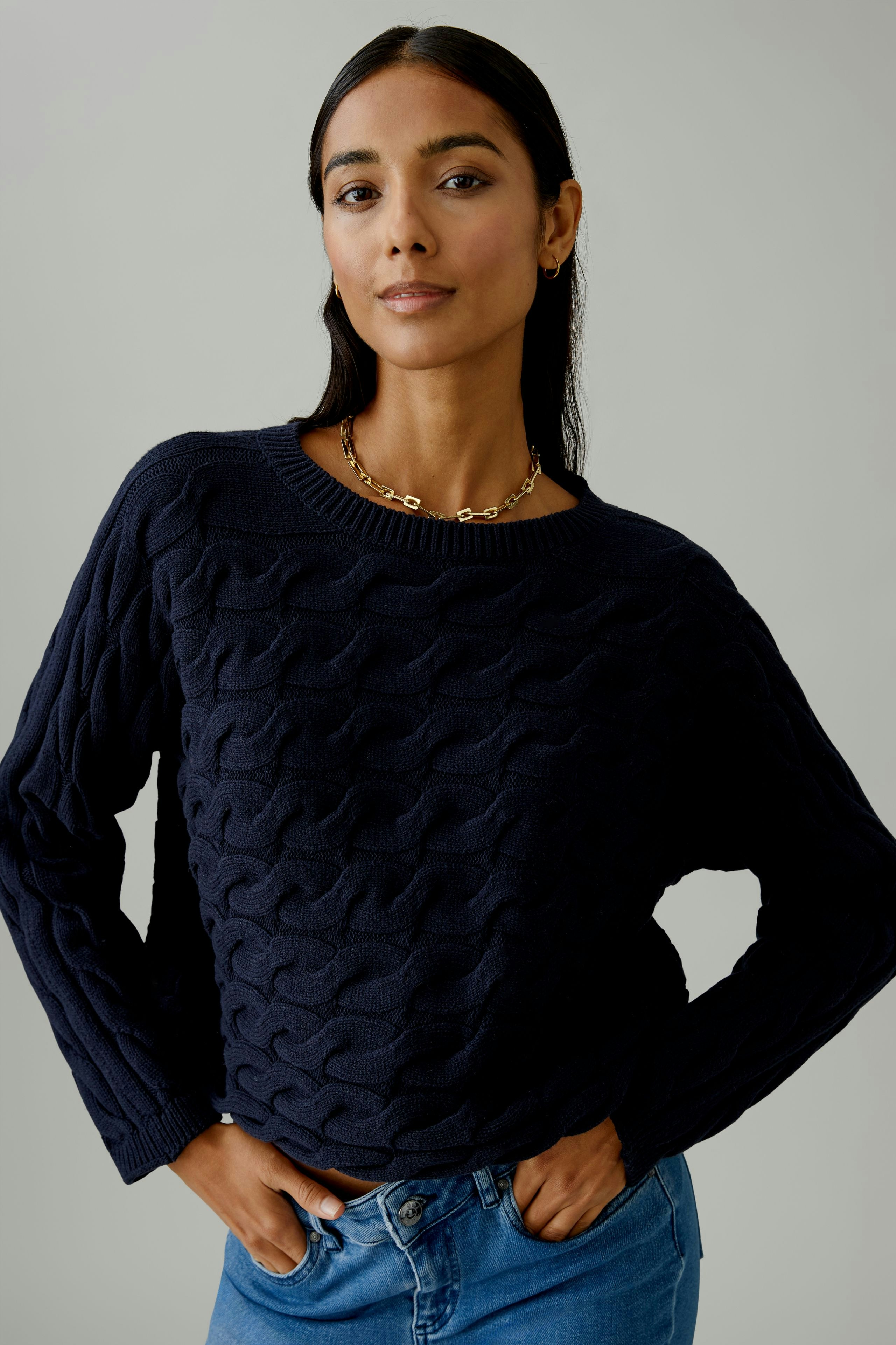 Casual women's pullover: Young woman in a navy knitted pullover with a textured pattern.