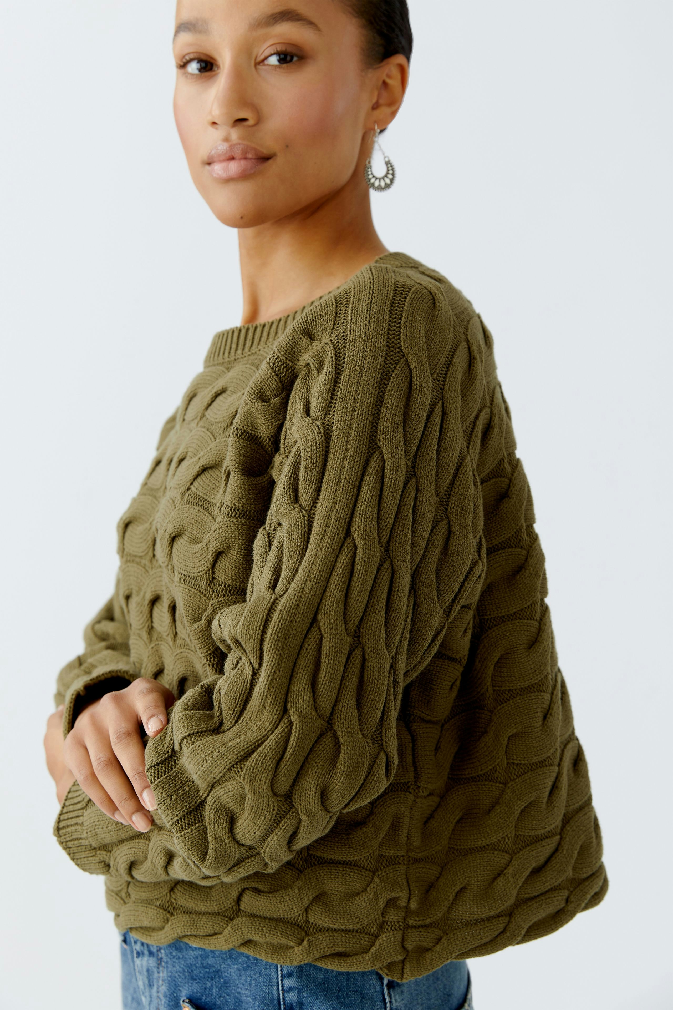 Casual women's pullover: A woman in a textured olive green pullover with a relaxed fit.