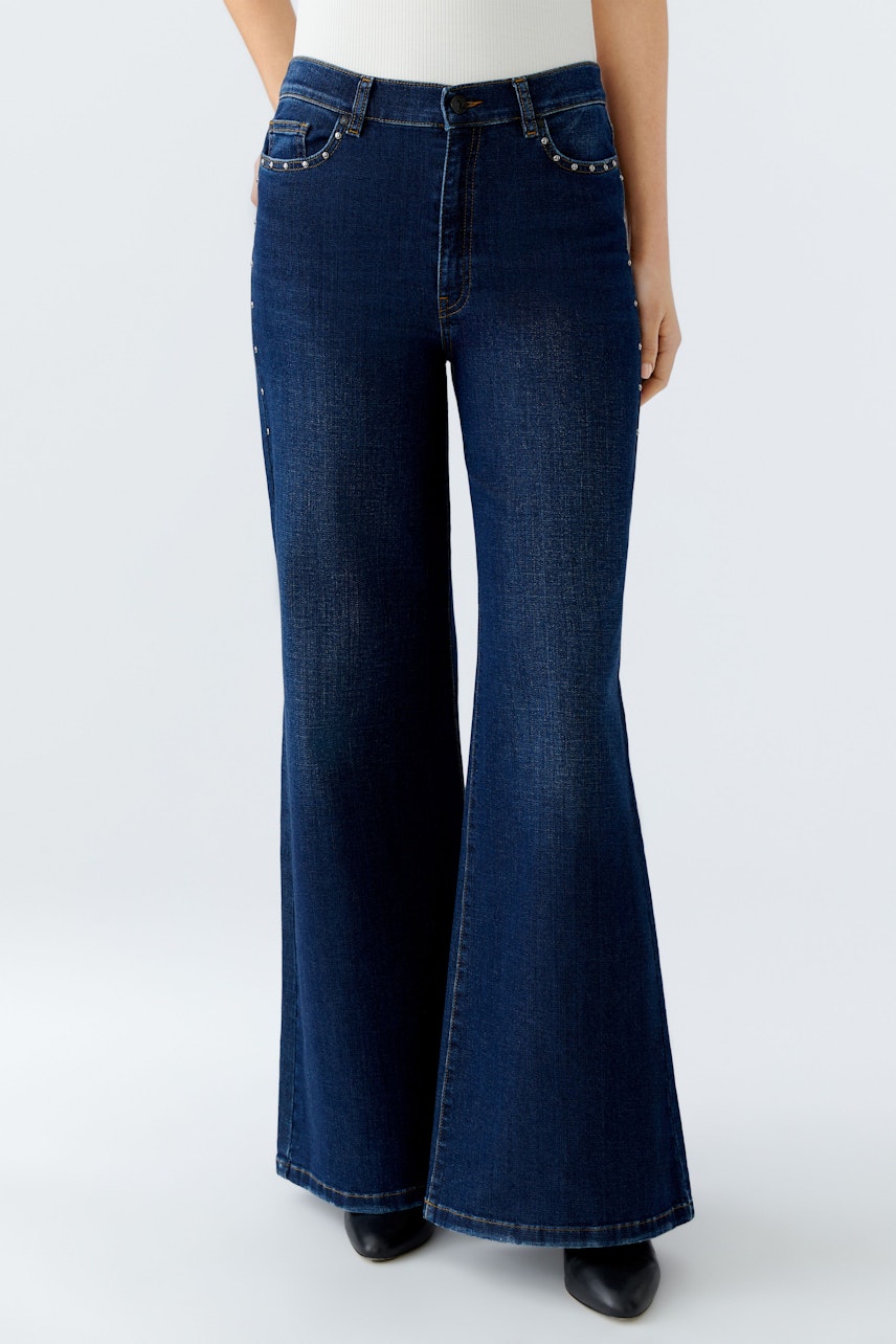 Damen Jeans Wide Leg: Frau trägt weite Jeans in dunklem Denim, kombiniert mit einem schlichten Oberteil.