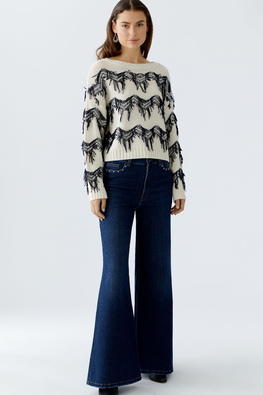 Damen Jeans Wide Leg: Frau trägt weite Jeans in dunklem Denim, kombiniert mit einem lässigen Pullover.